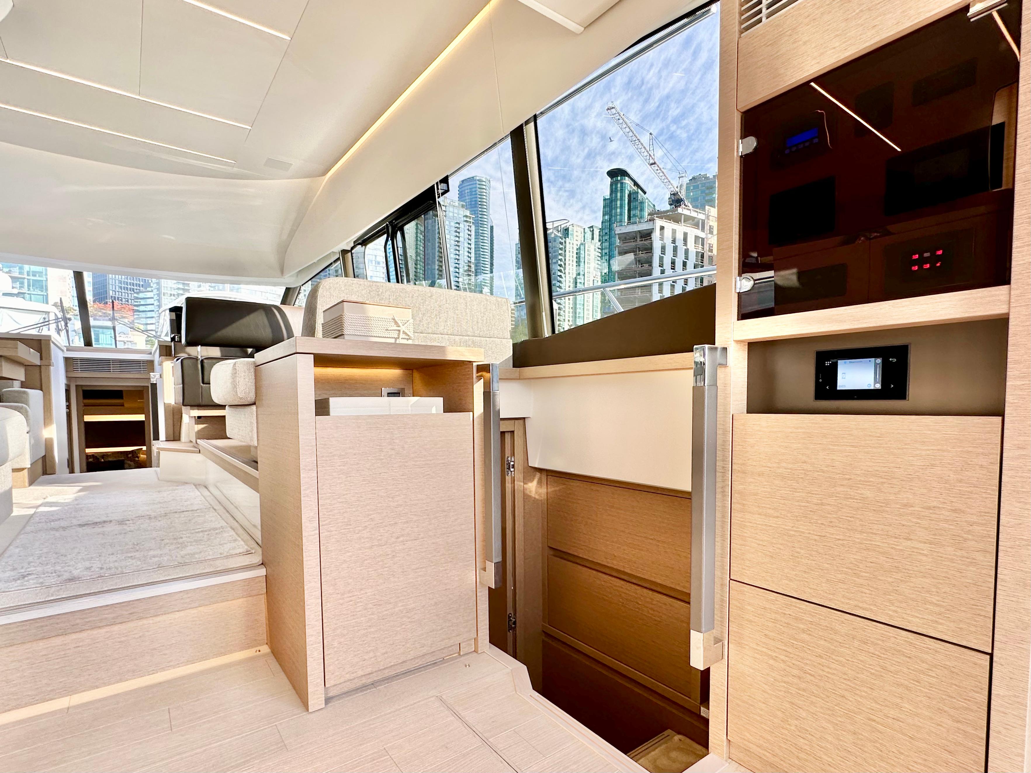 Luxurious interior of 2023 Prestige 520 yacht with modern design and cityscape view.