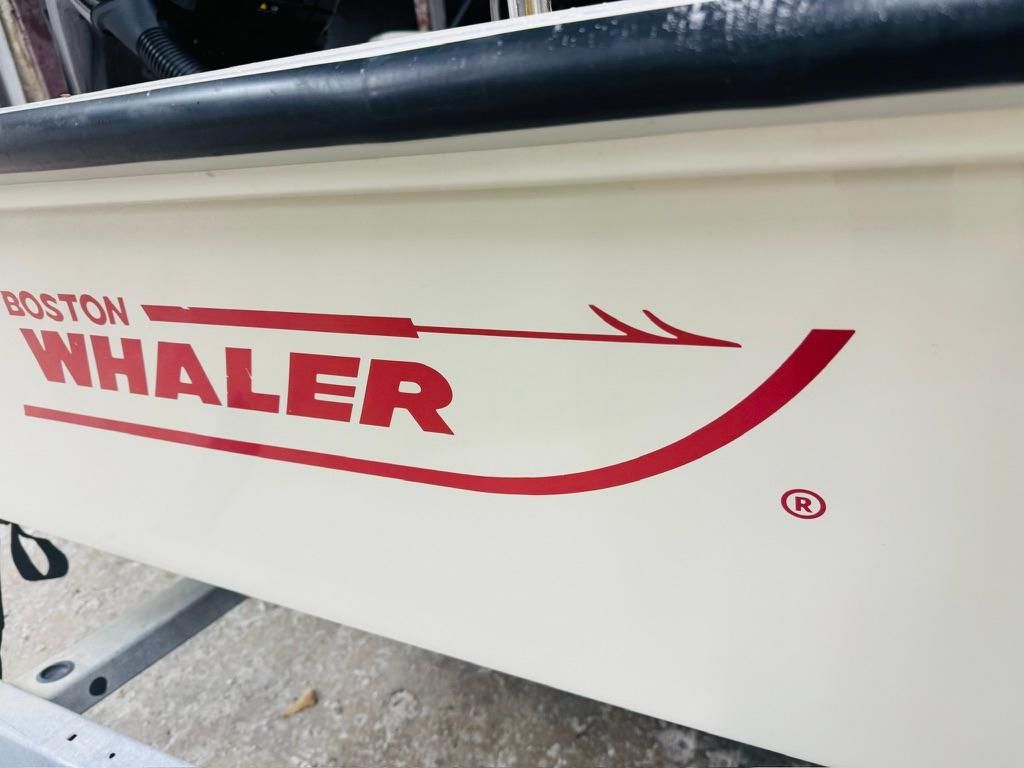 Close-up of the 1986 Boston Whaler 17 Montauk with red logo on white hull.