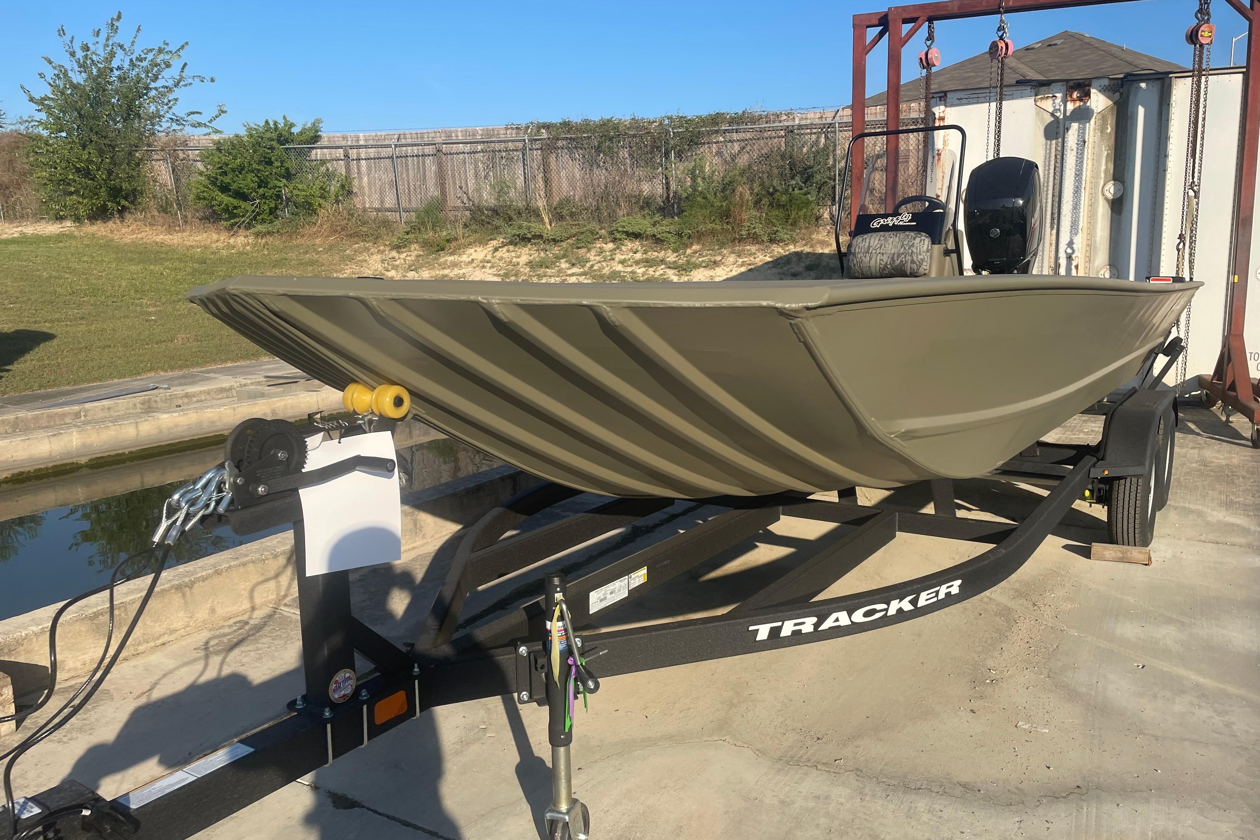 2026 Tracker Grizzly 2072 CC boat on trailer, parked outdoors.