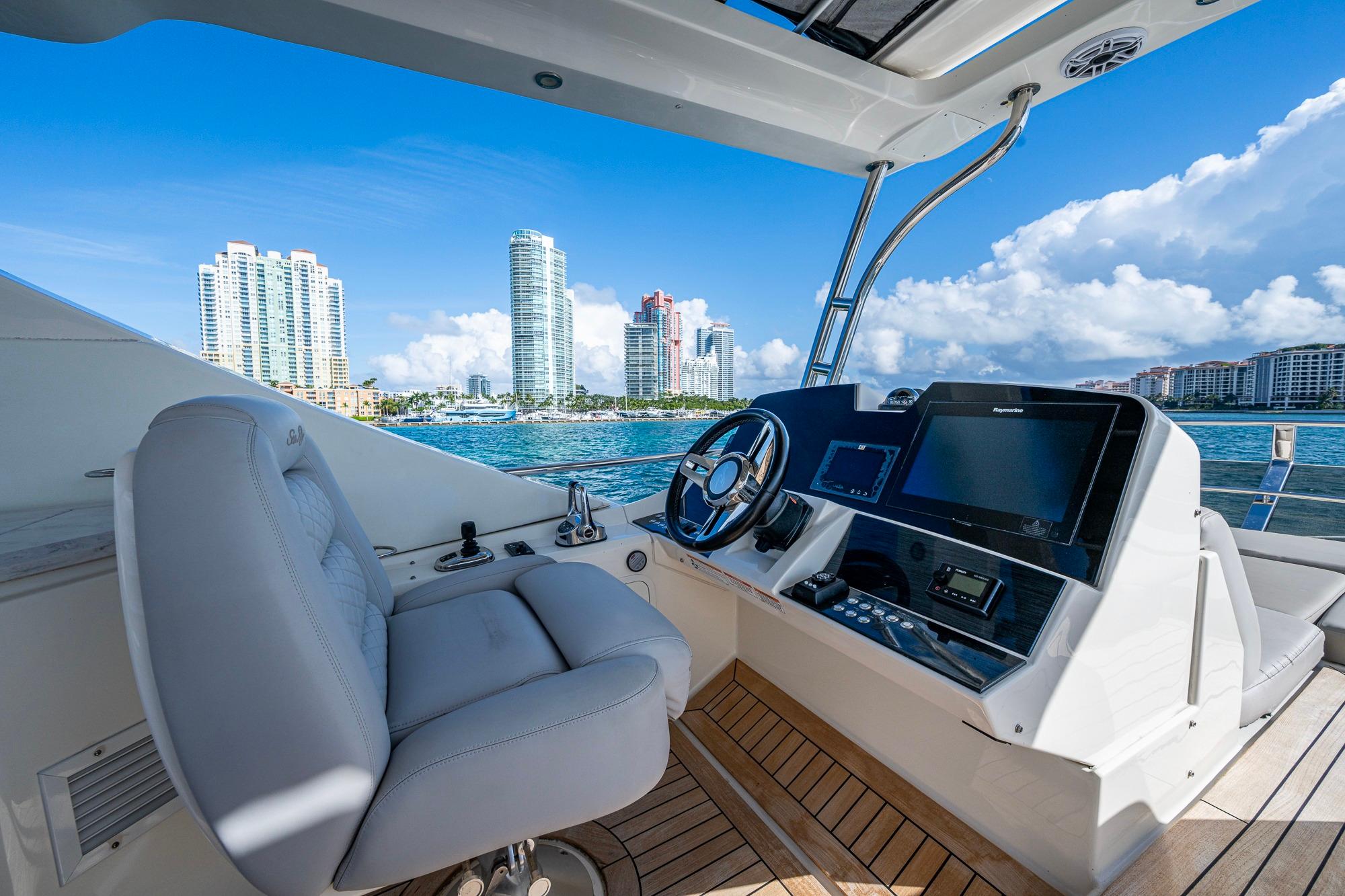 Helm of 2018 Sea Ray L550 Fly yacht with city skyline in background.