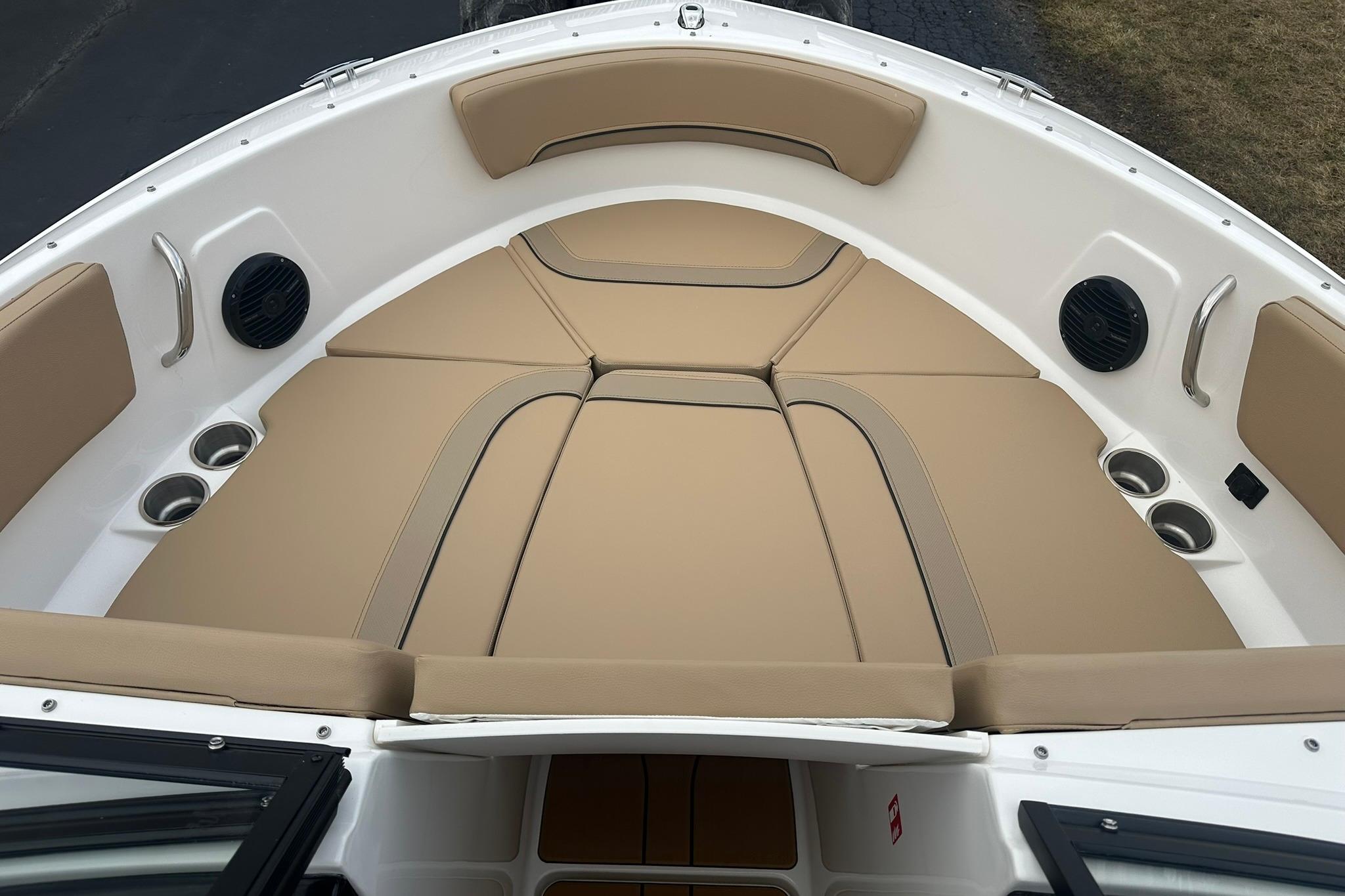 2026 Bayliner V20 boat interior with tan cushioned seating and cup holders.