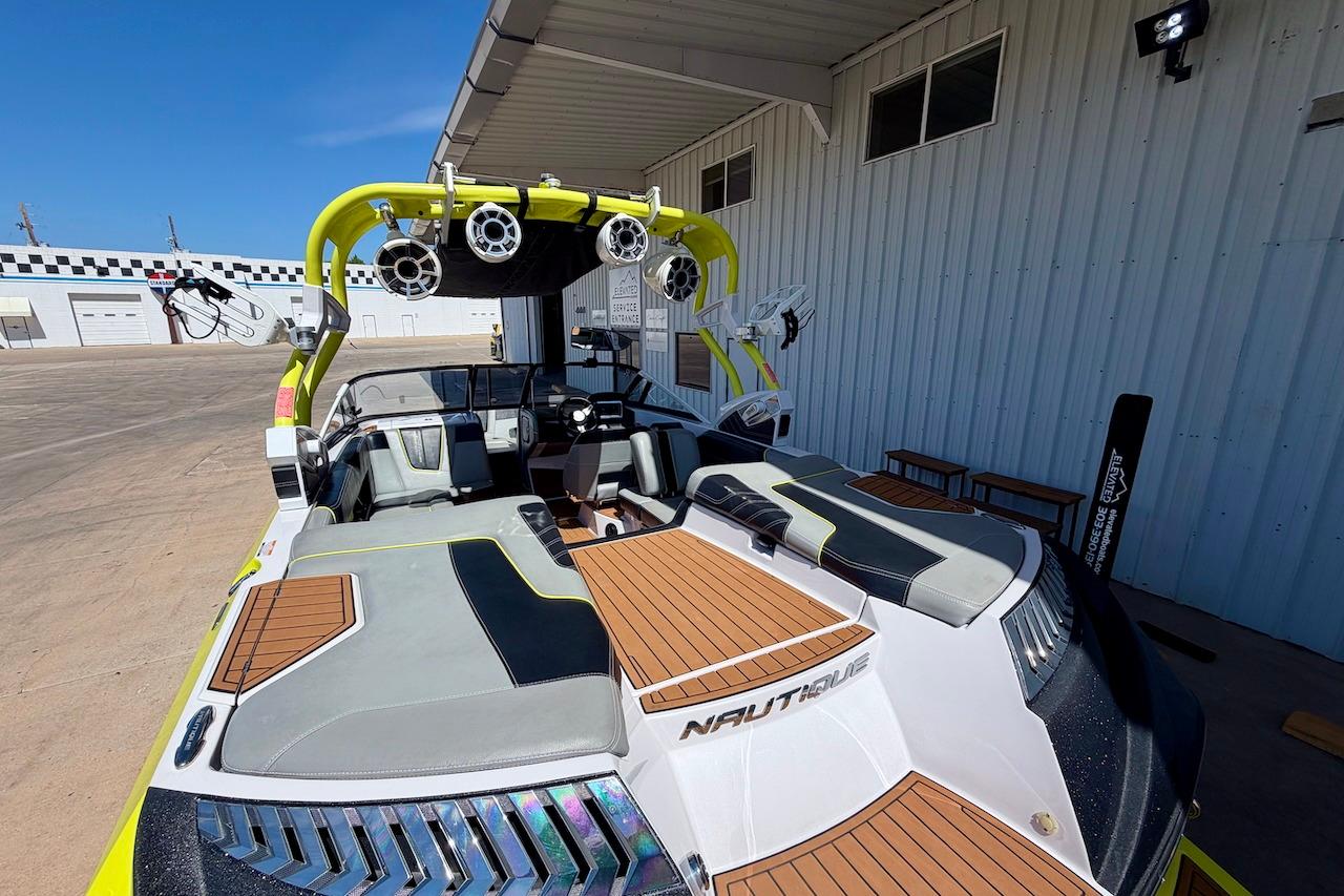 2014 Nautique Super Air Nautique G21 boat with stylish seating and audio system, docked outdoors.