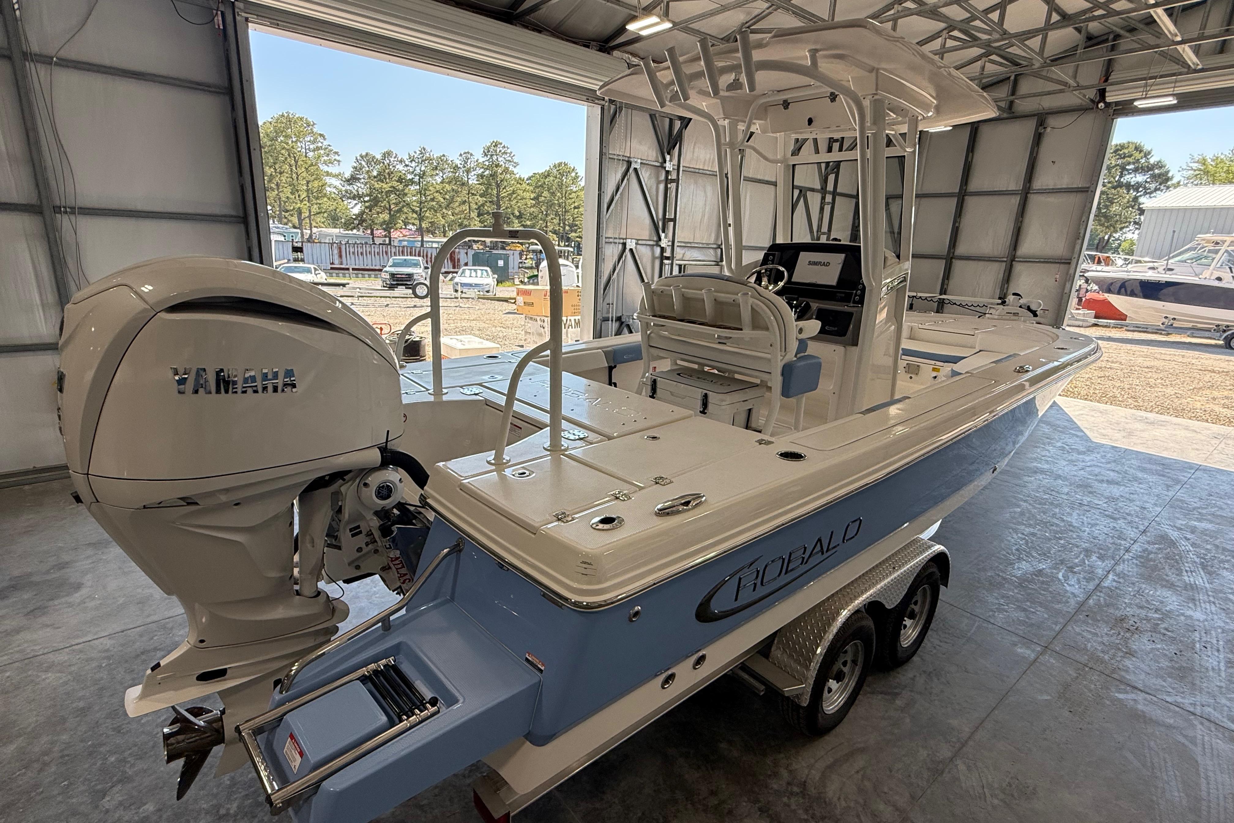 2026 Robalo 246 Cayman boat with Yamaha engine in a garage setting.
