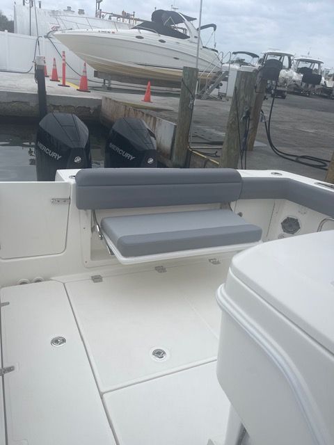 Boston Whaler 330 Outrage 2023 with gray bench at dock.