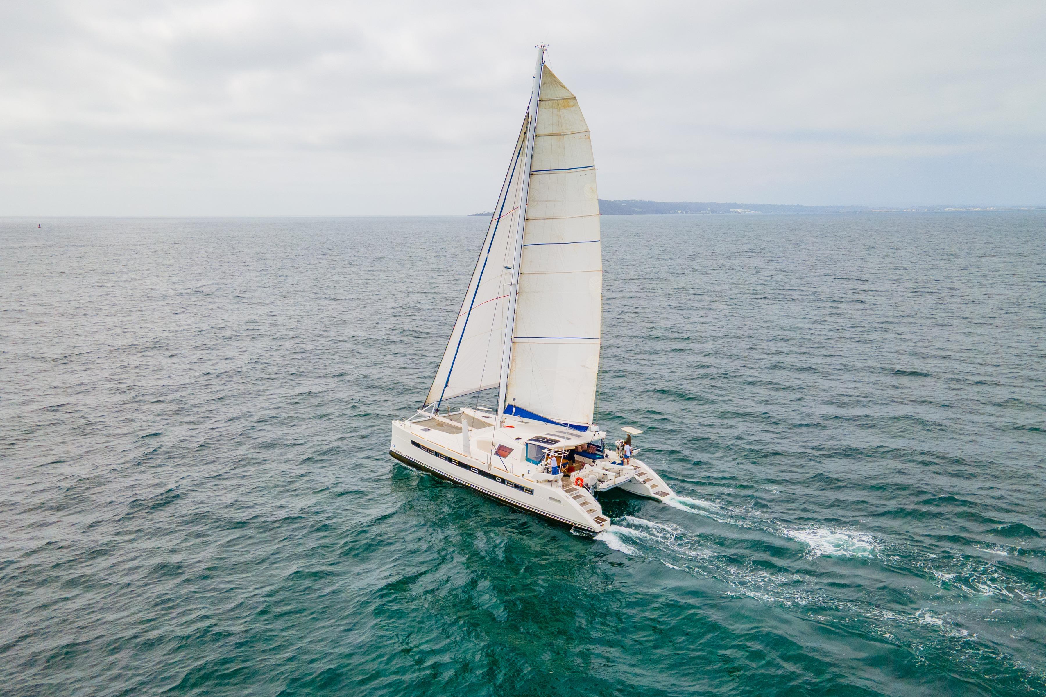 Catana 65 catamaran sailing on open sea, 2009 model, with full sails.