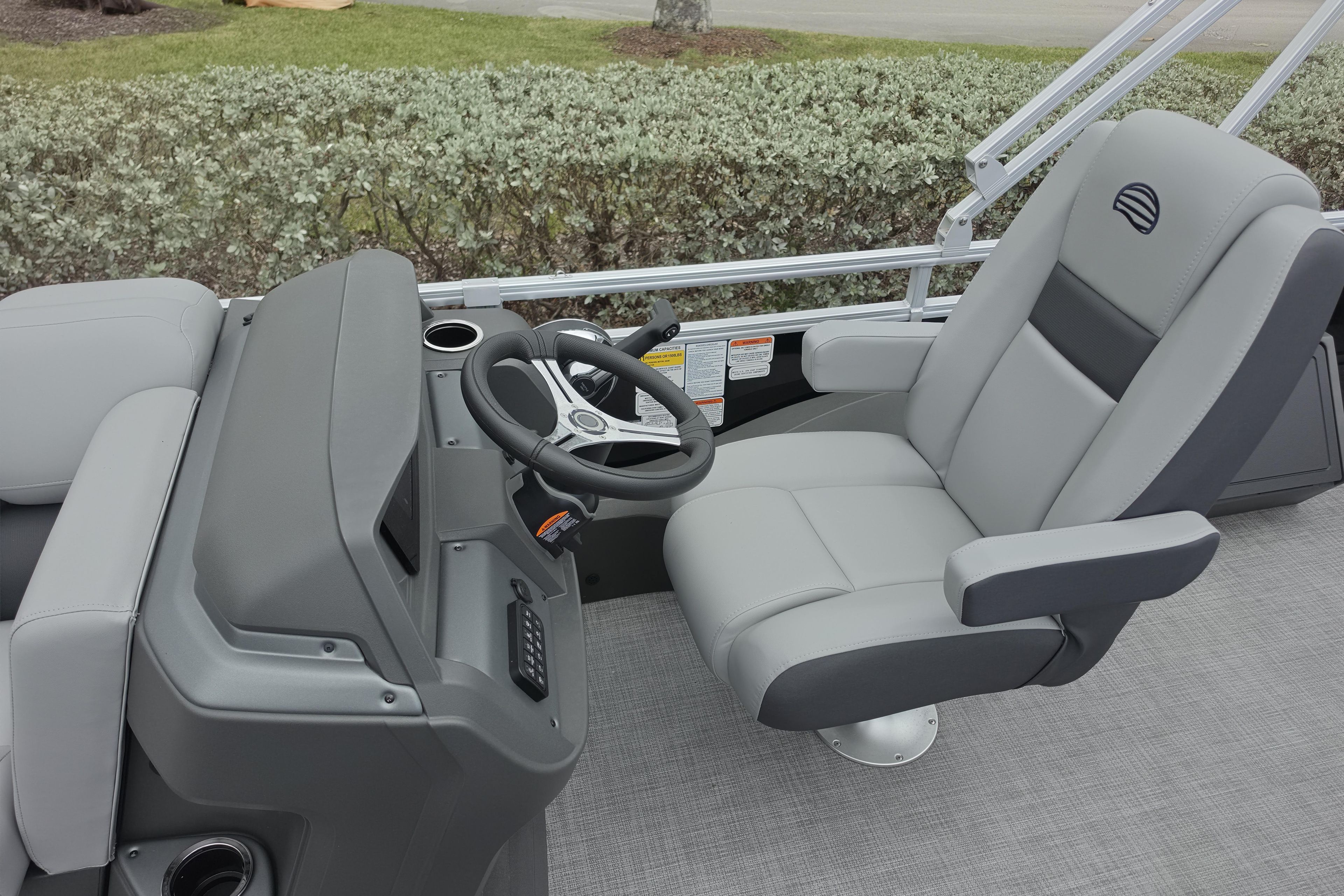 2026 Sun Tracker SportFish 22 XP3 boat interior with steering wheel and captain's chair.