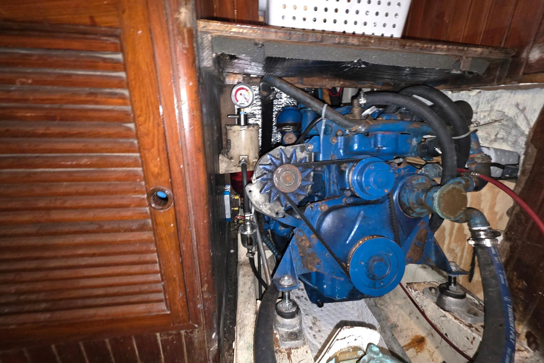 Engine compartment of a 1982 Tayana 37 sailboat, featuring a blue marine engine.