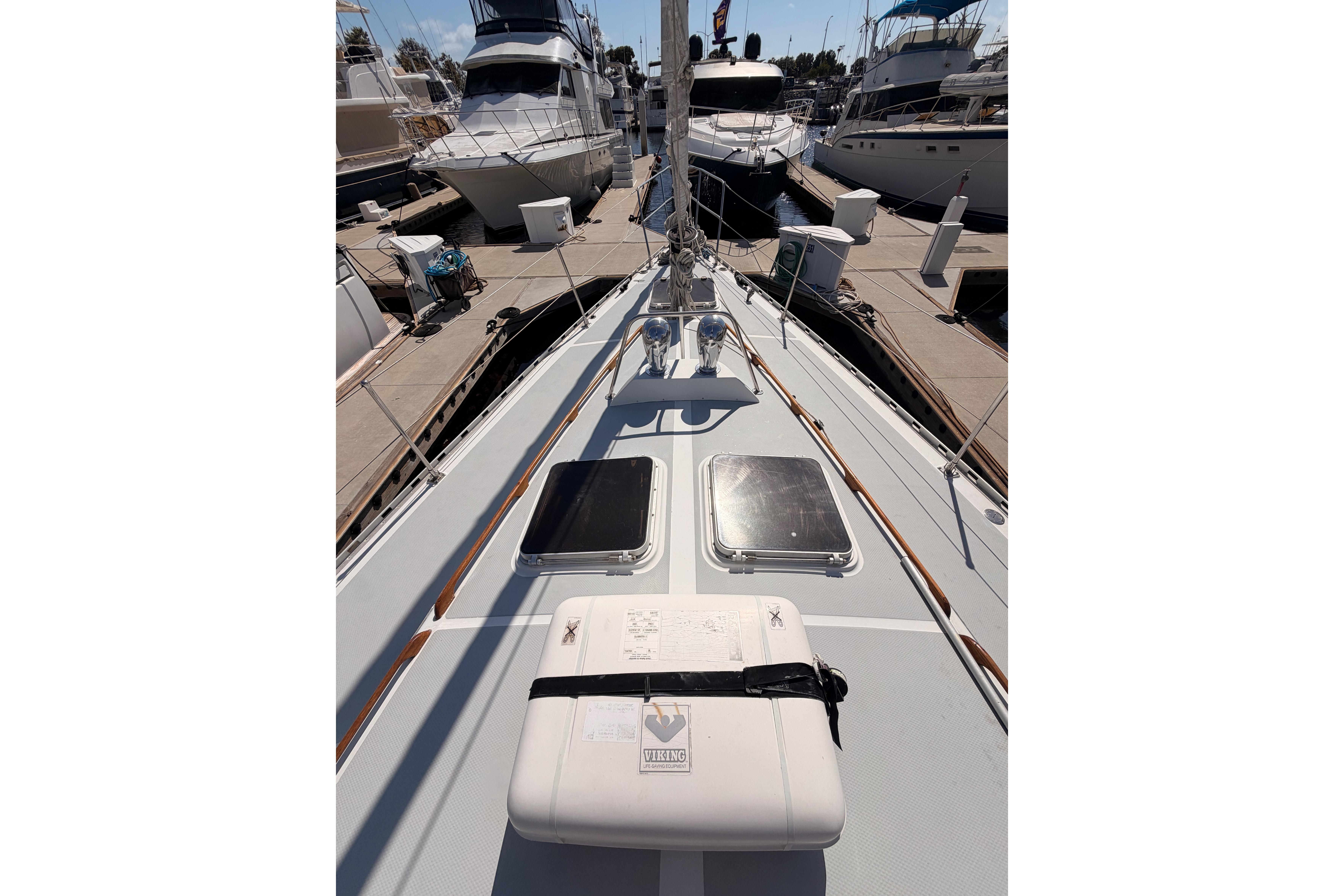 1991 Hylas 51 yacht deck view at marina, showcasing sleek design and docked boats.