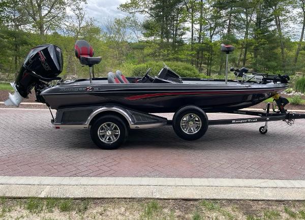 2025 Ranger Z518 boat on trailer, parked on brick road, surrounded by trees.