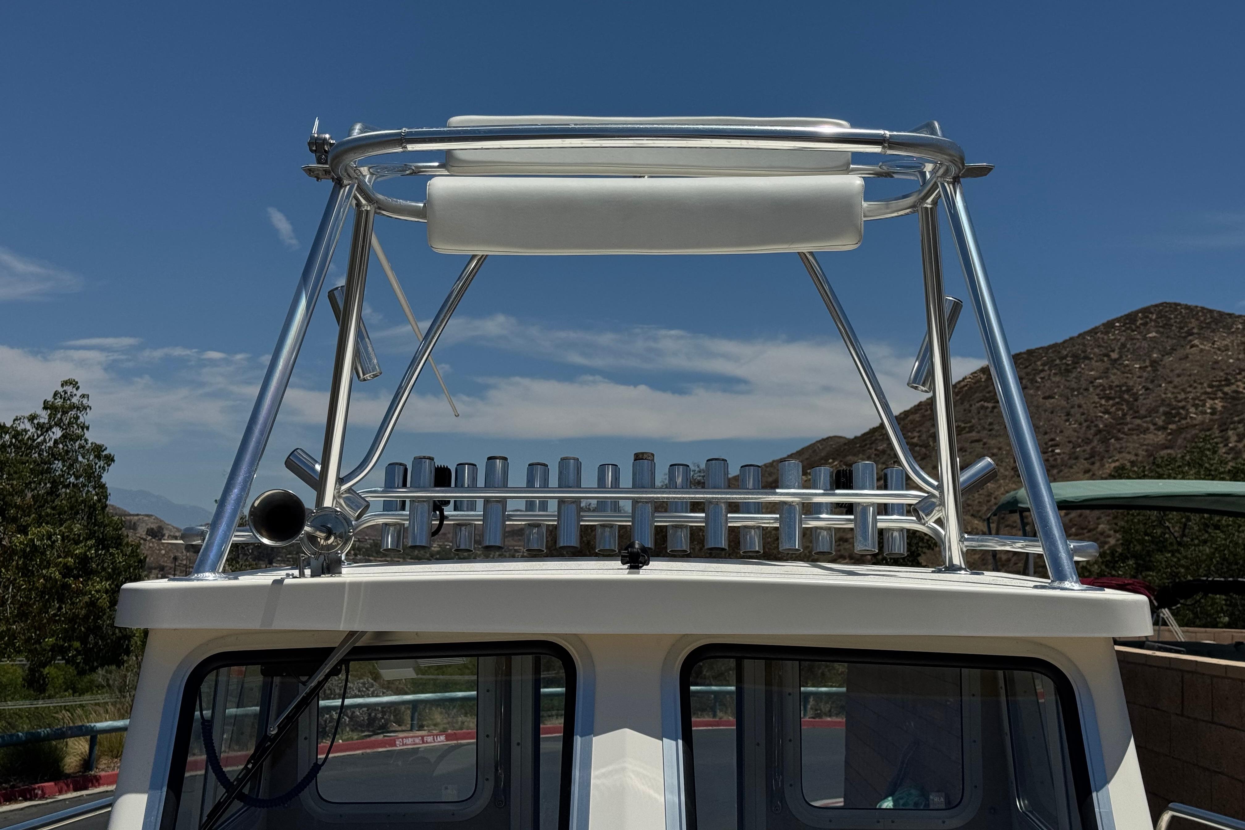 2017 Defiance Admiral 220 EX boat with rod holders and tower against a mountainous backdrop.