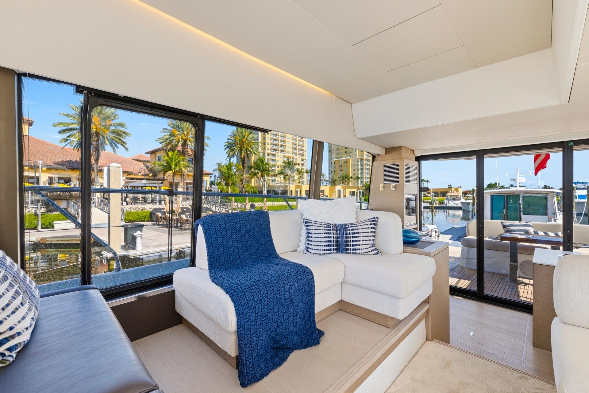 Luxurious interior of 2022 Prestige 520 yacht with elegant seating and marina view.