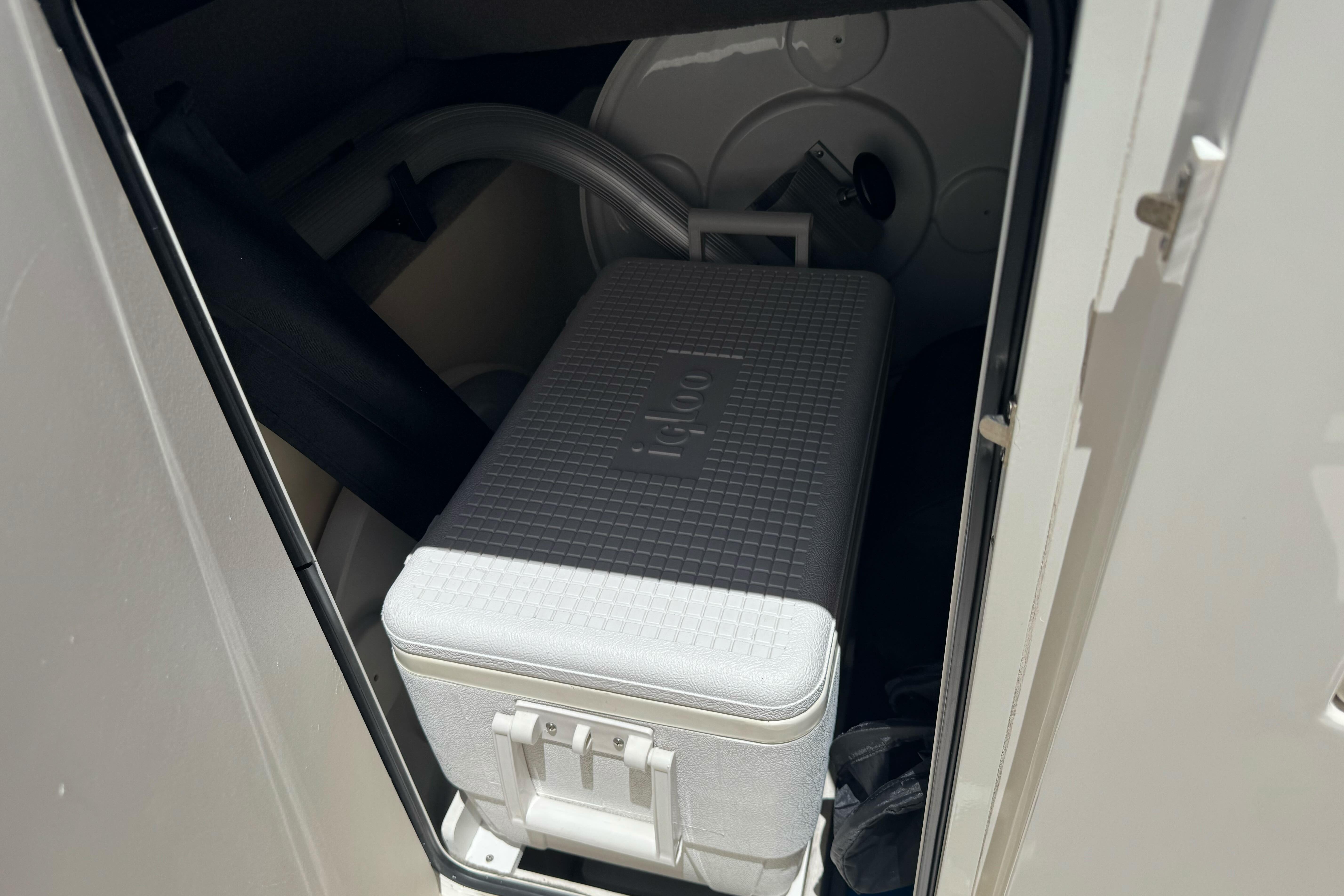 Storage compartment in a 2007 Sea Ray SLX 250 boat with an Igloo cooler inside.