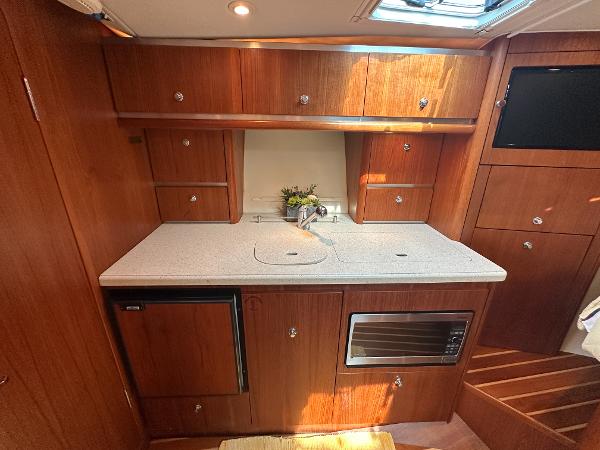 2006 Tiara Yachts 3200 Open galley with wood cabinetry and modern appliances.