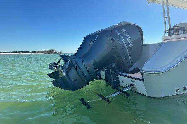 Edgewater 320CC 2015 boat with Yamaha outboard motor in calm green water.