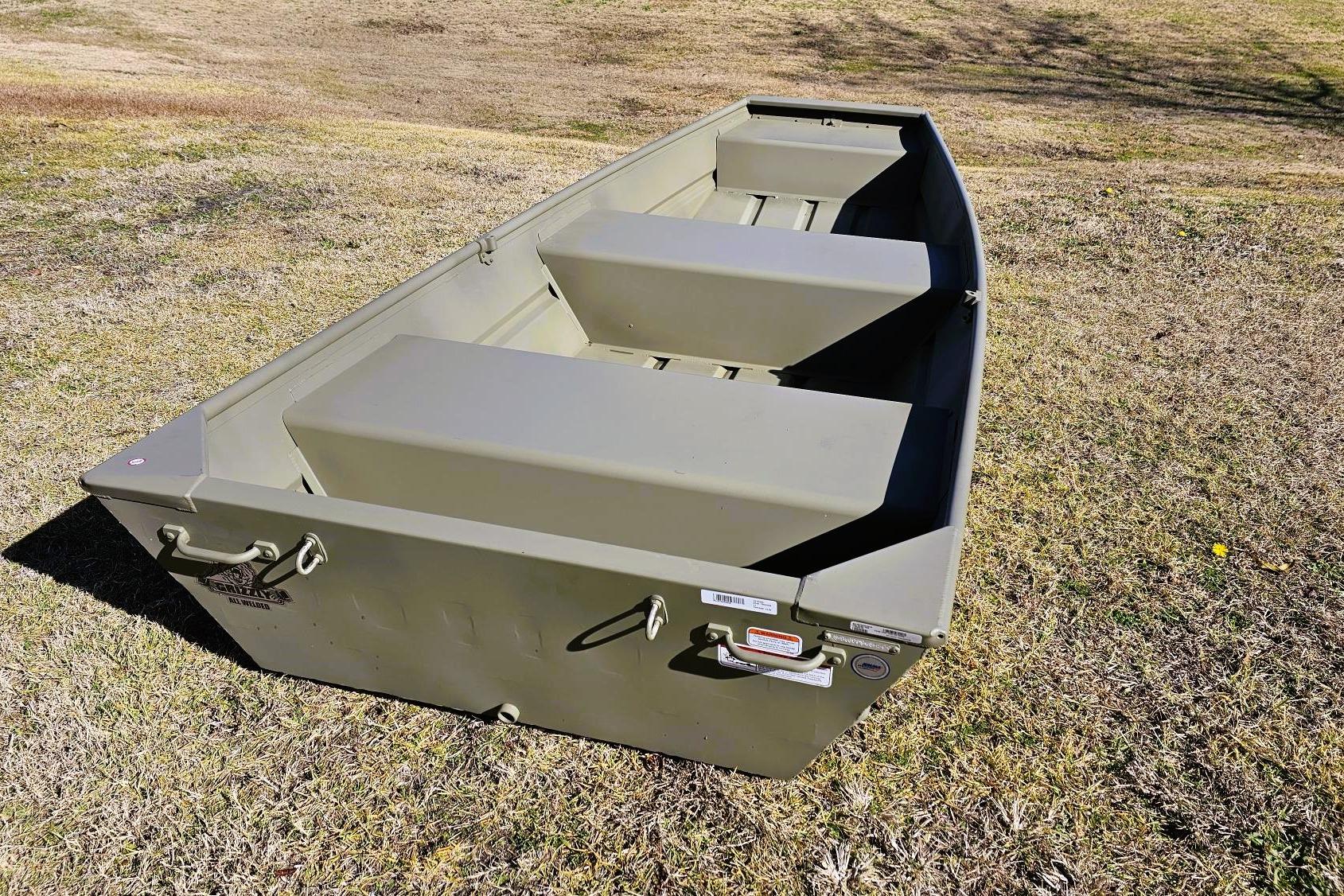 2026 Tracker Grizzly 12 Jon boat on grassy terrain, showcasing durable design.