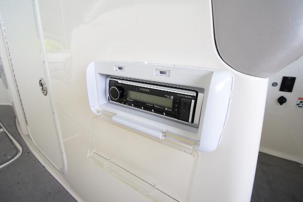 A built-in radio on a boat panel with white surfaces.