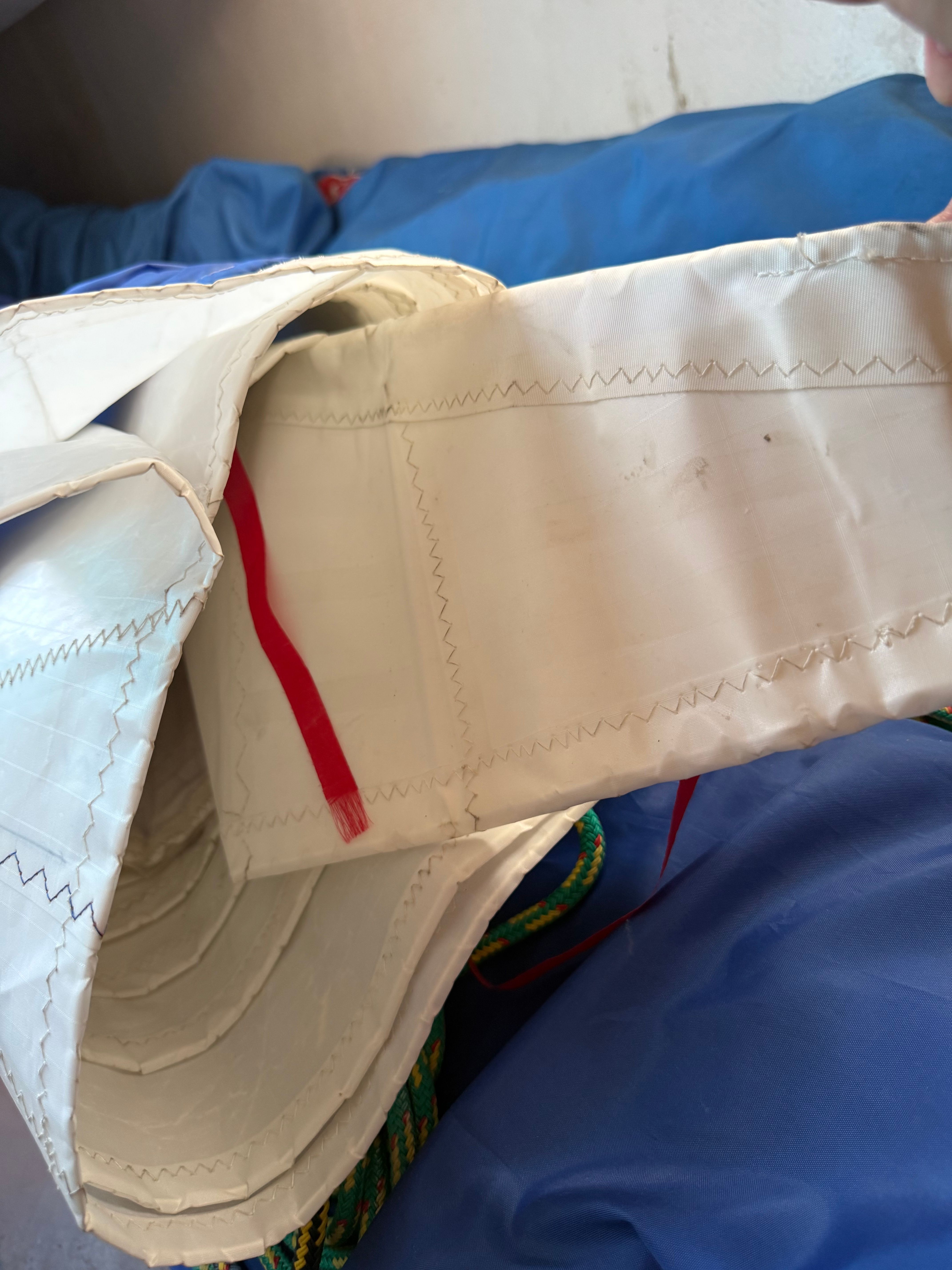 Close-up of a sail with red and blue details.