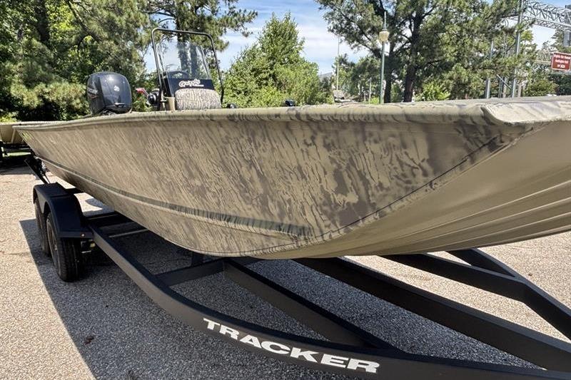 2026 Tracker Grizzly 2072 CC boat on trailer, camo design, parked outdoors.