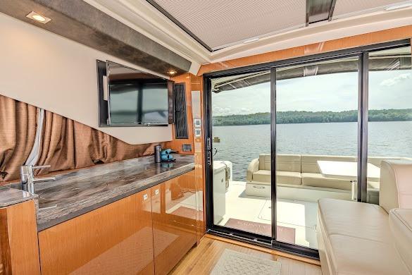 Luxurious interior of 2016 Sea Ray Sundancer 510 yacht with lake view through glass doors.