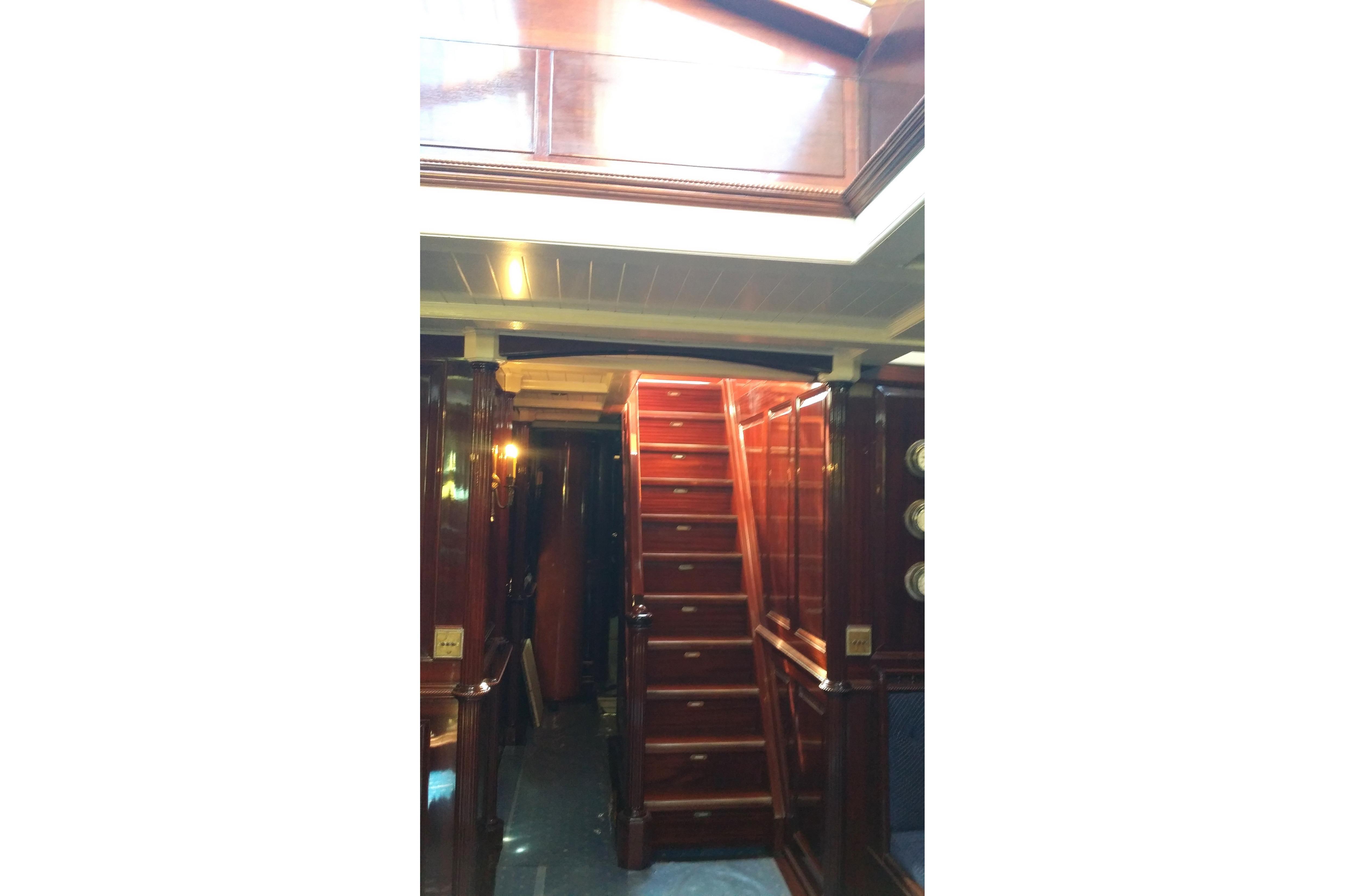 Interior of 1930 Frederikksund Gaff Topsail Schooner with polished wooden staircase and paneling.