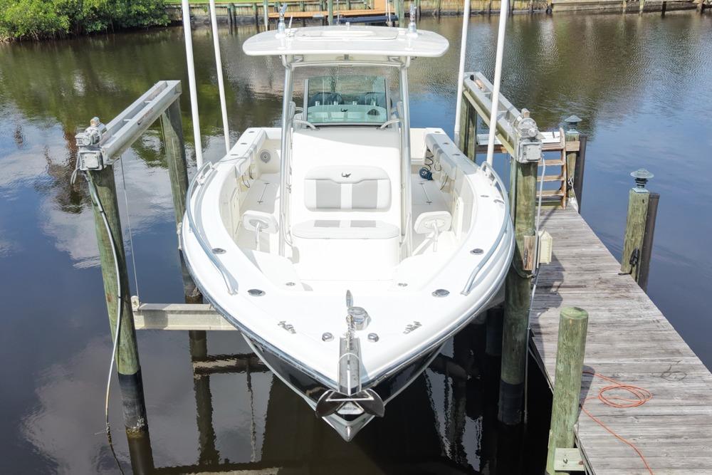 2018 Mako 284 Center Console boat docked on calm water.