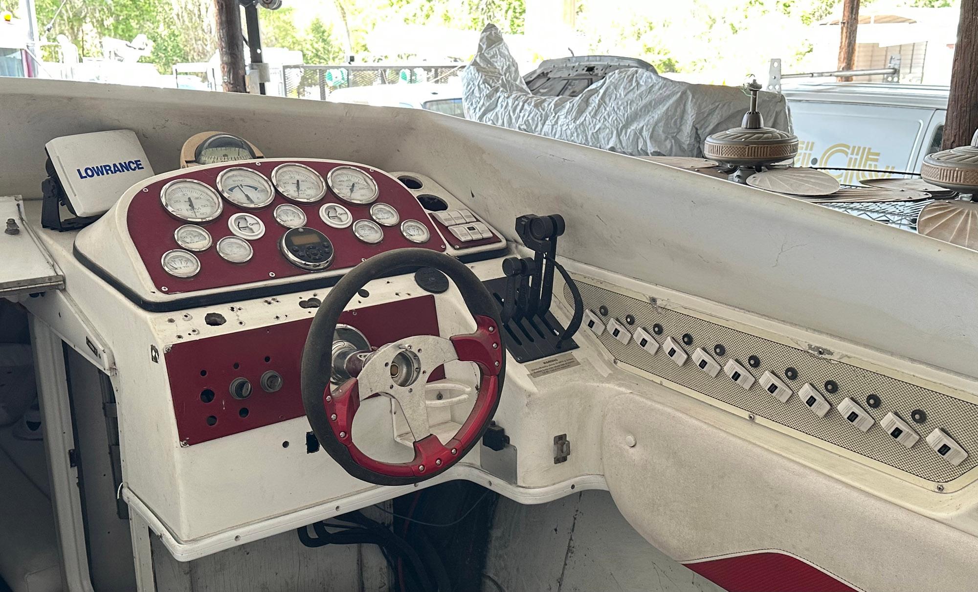 1997 Baja Outlaw 32 boat dashboard with steering wheel and gauges.