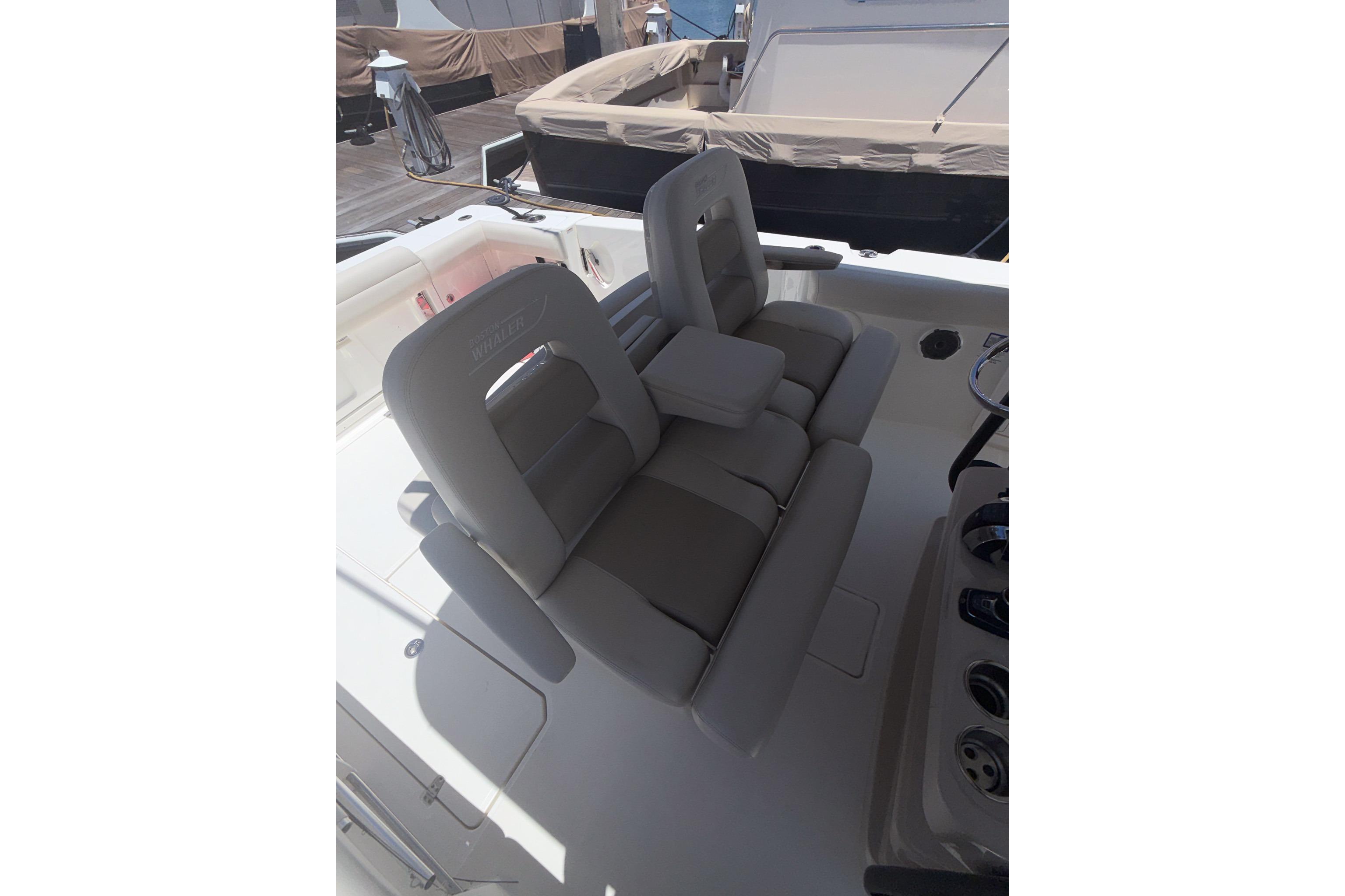 2021 Boston Whaler 330 Outrage boat interior with cushioned seating and console.