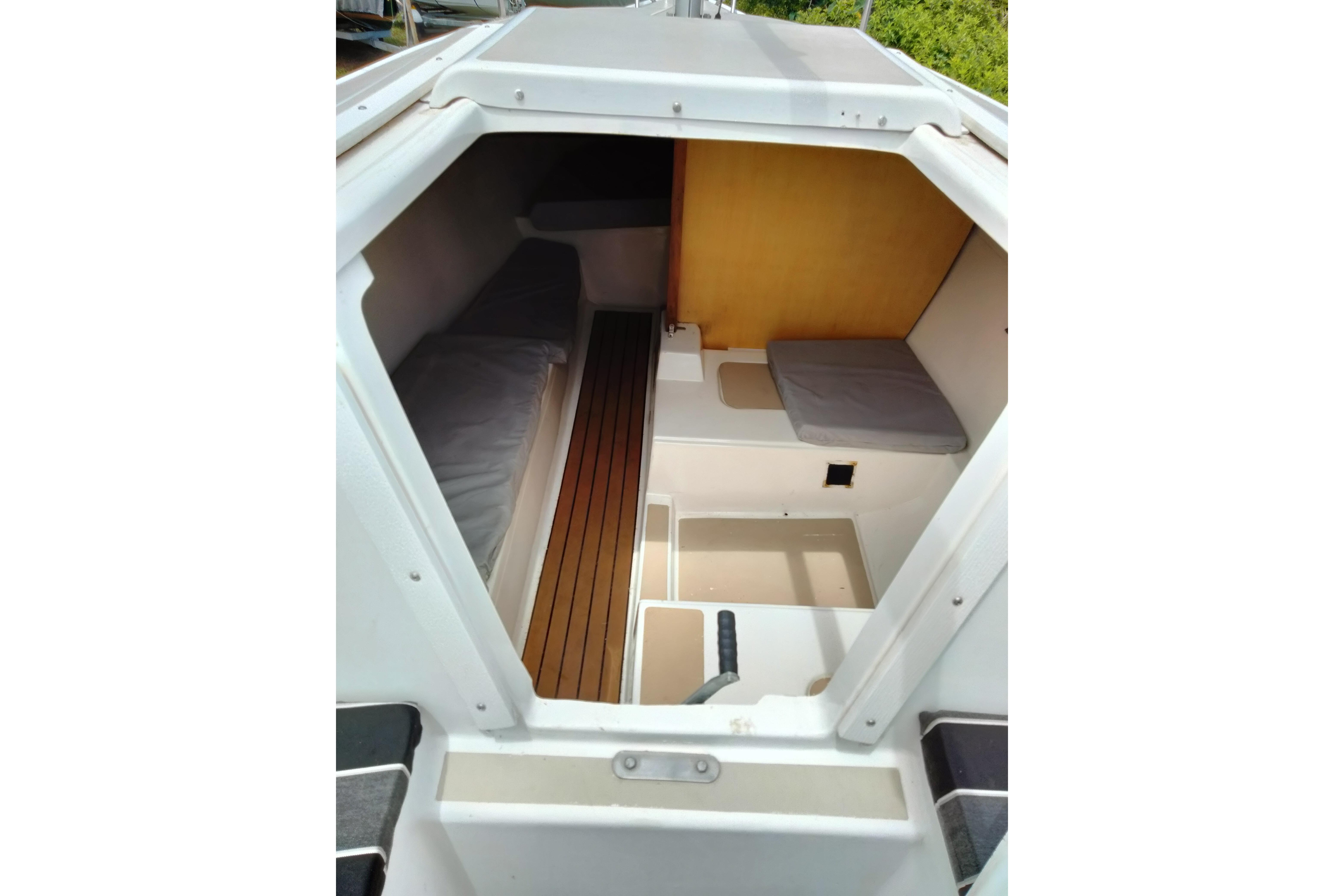 Interior view of a 1980 MacGregor 25 sailboat cabin with wooden flooring.
