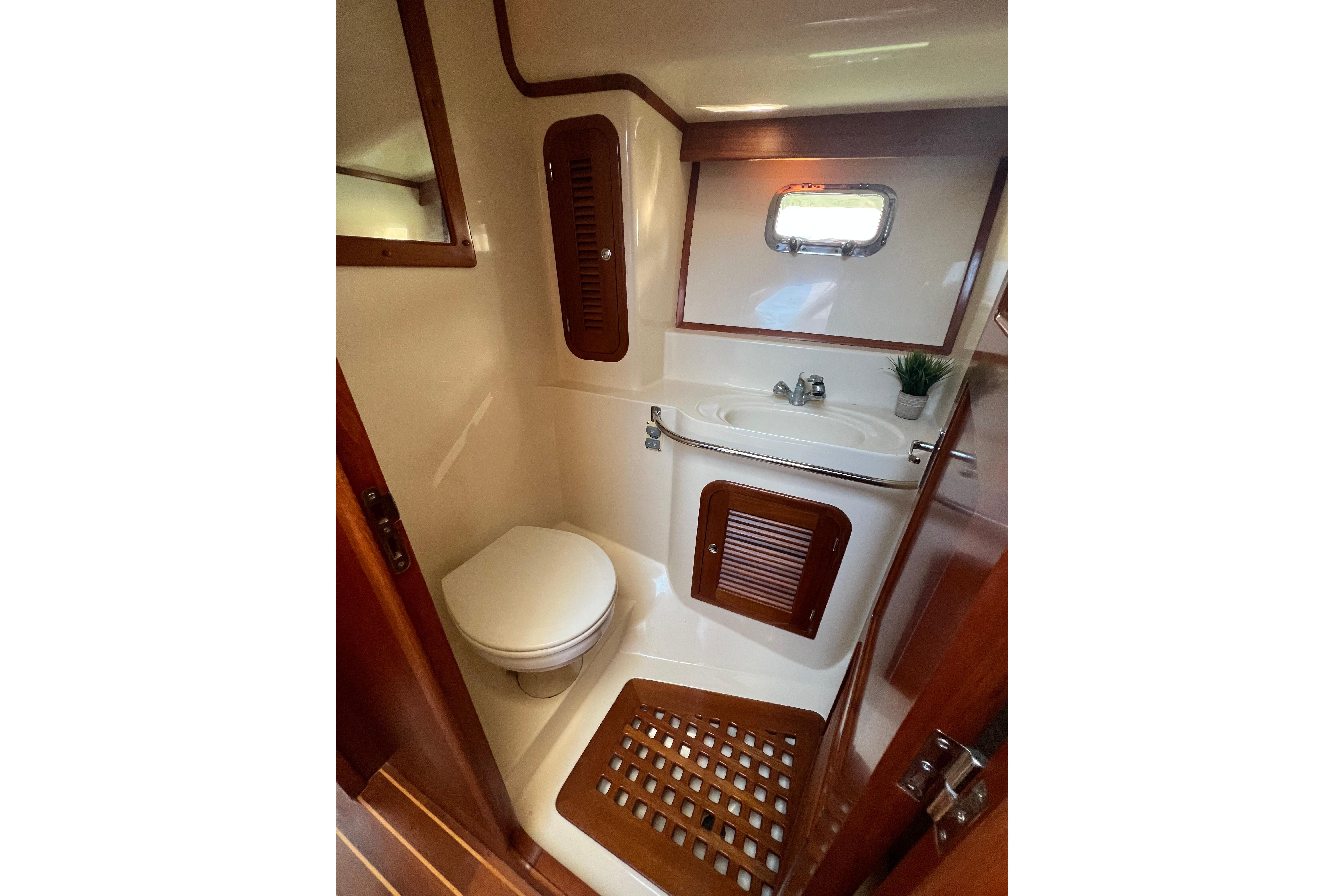 Bathroom interior of 2007 Heritage East 36 Sundeck Trawler with wooden accents.