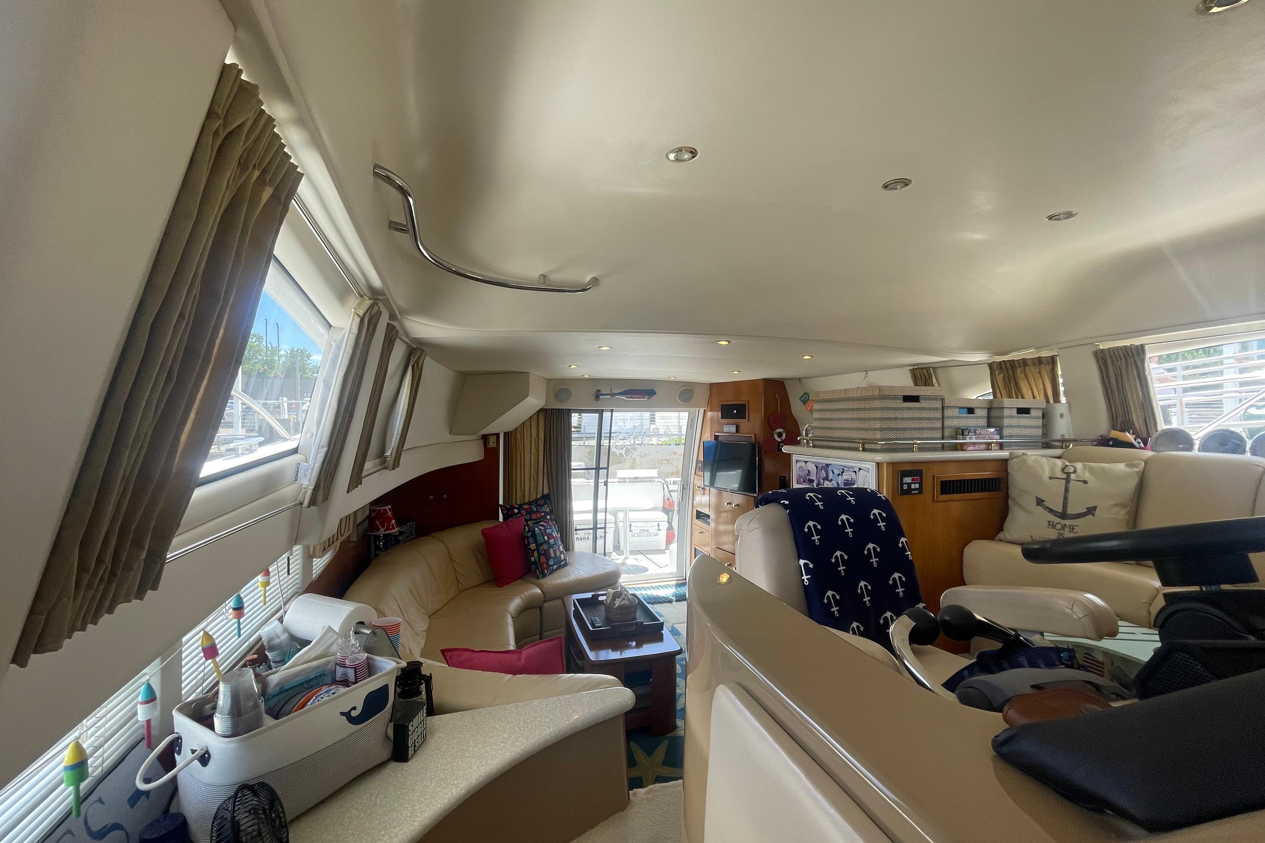 Interior of a 2002 Carver 410 Sport Sedan yacht, featuring cozy seating and nautical decor.