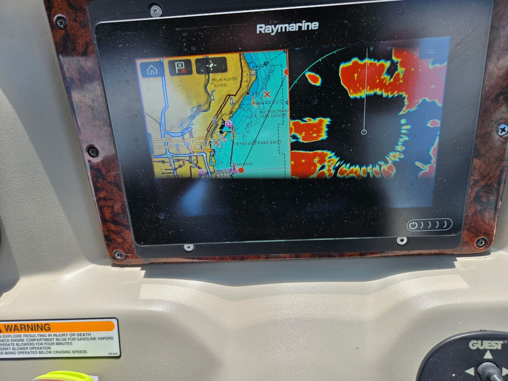 A Raymarine navigation system on a boat displays maps and radar.