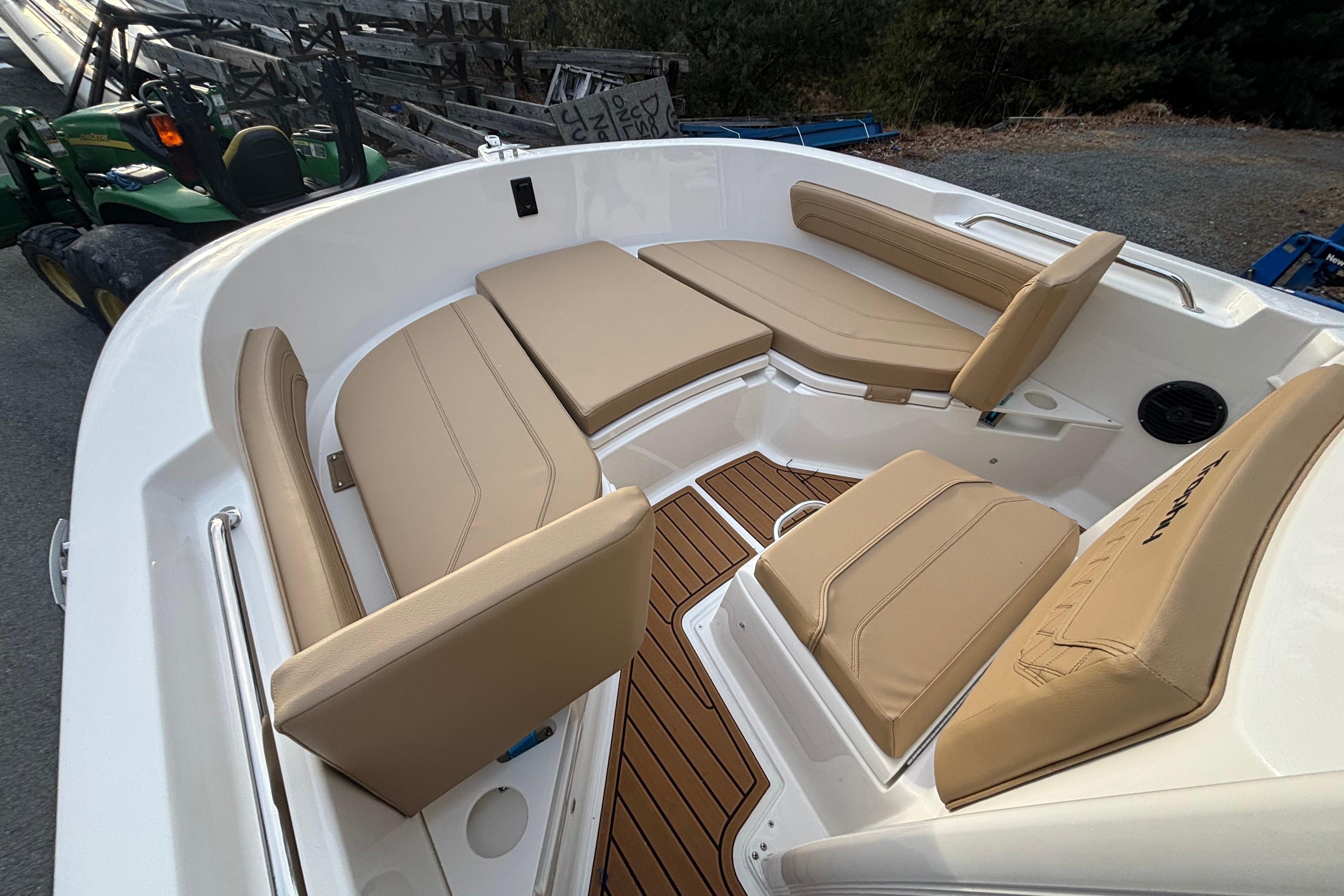 2026 Bayliner Trophy T20CC boat interior with tan cushioned seating and wood-style flooring.