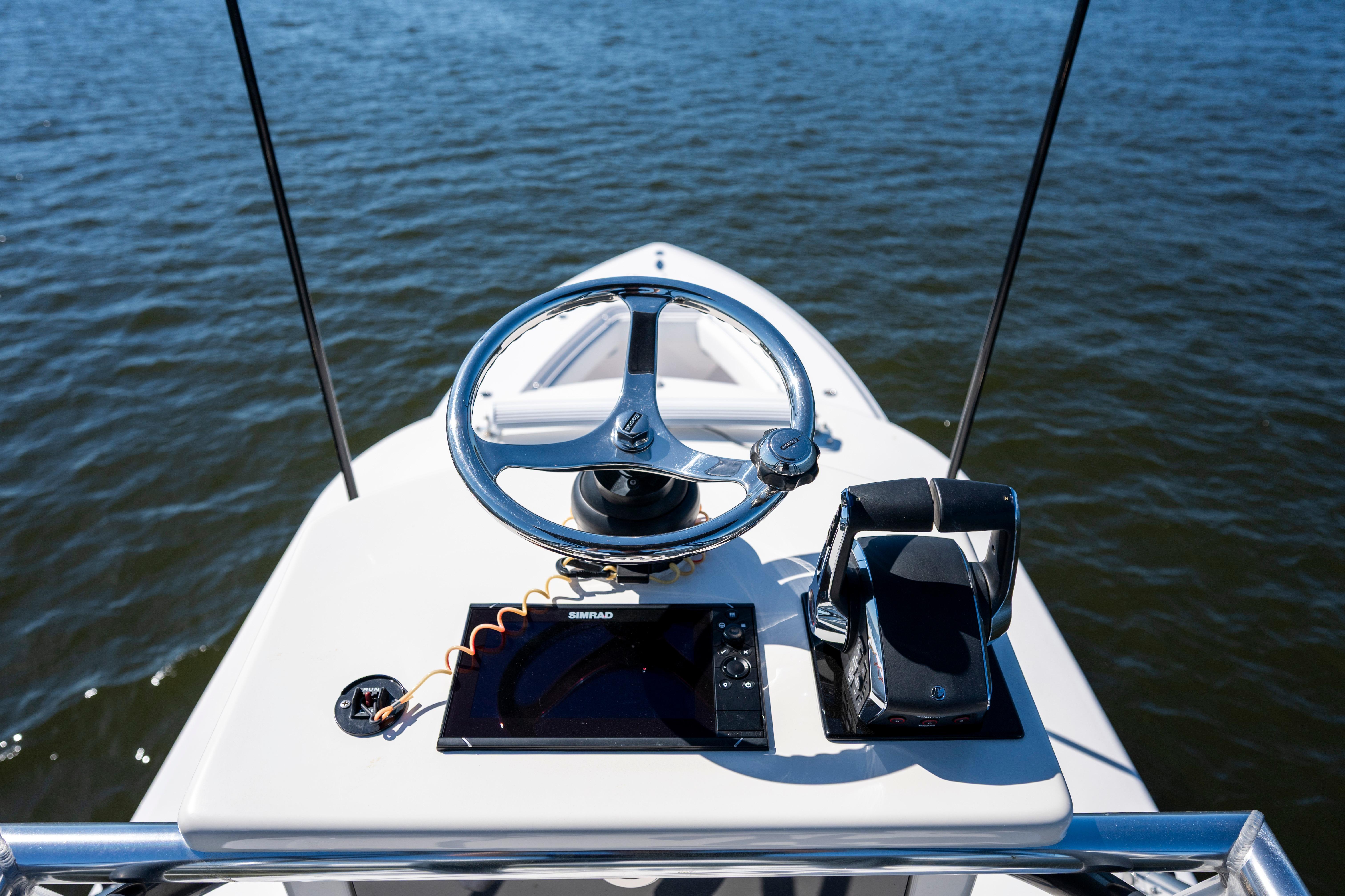 Helm of 2015 Contender 39 ST boat with steering wheel and navigation controls.