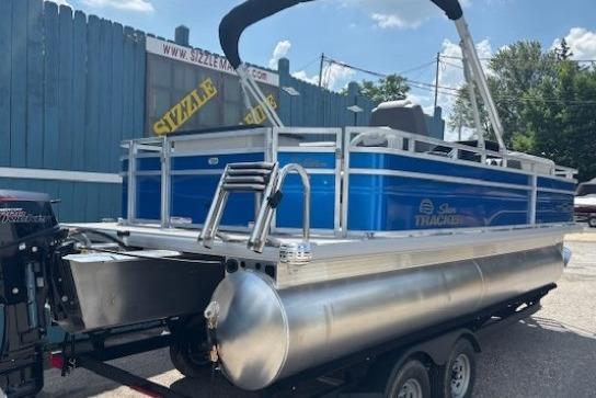 2026 Sun Tracker Fishin' Barge 20 DLX pontoon boat on trailer, blue exterior.