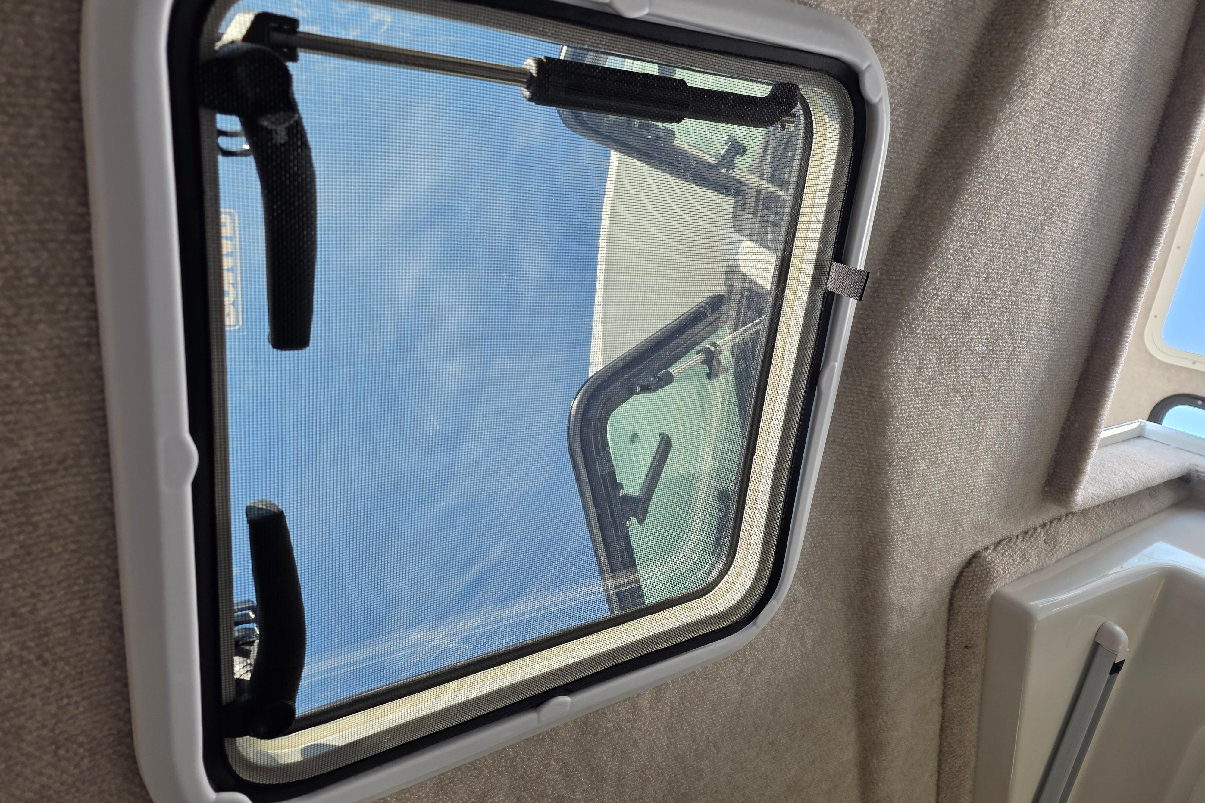 Cabin window view from 2026 Parker 287 Explorer boat, showing clear sky.