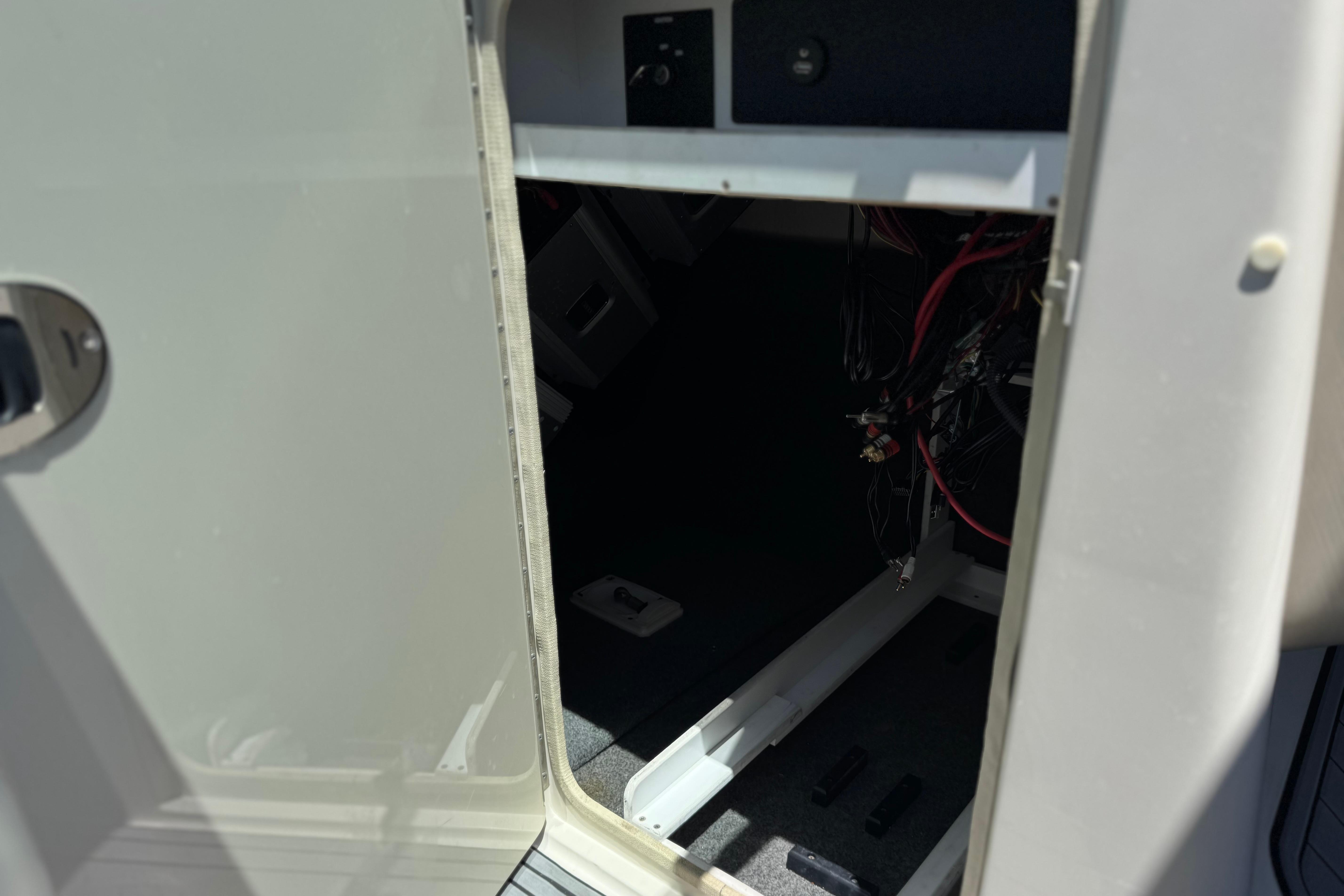 Open storage compartment on a 2007 Sea Ray 240 Sundeck boat, showing interior wiring.