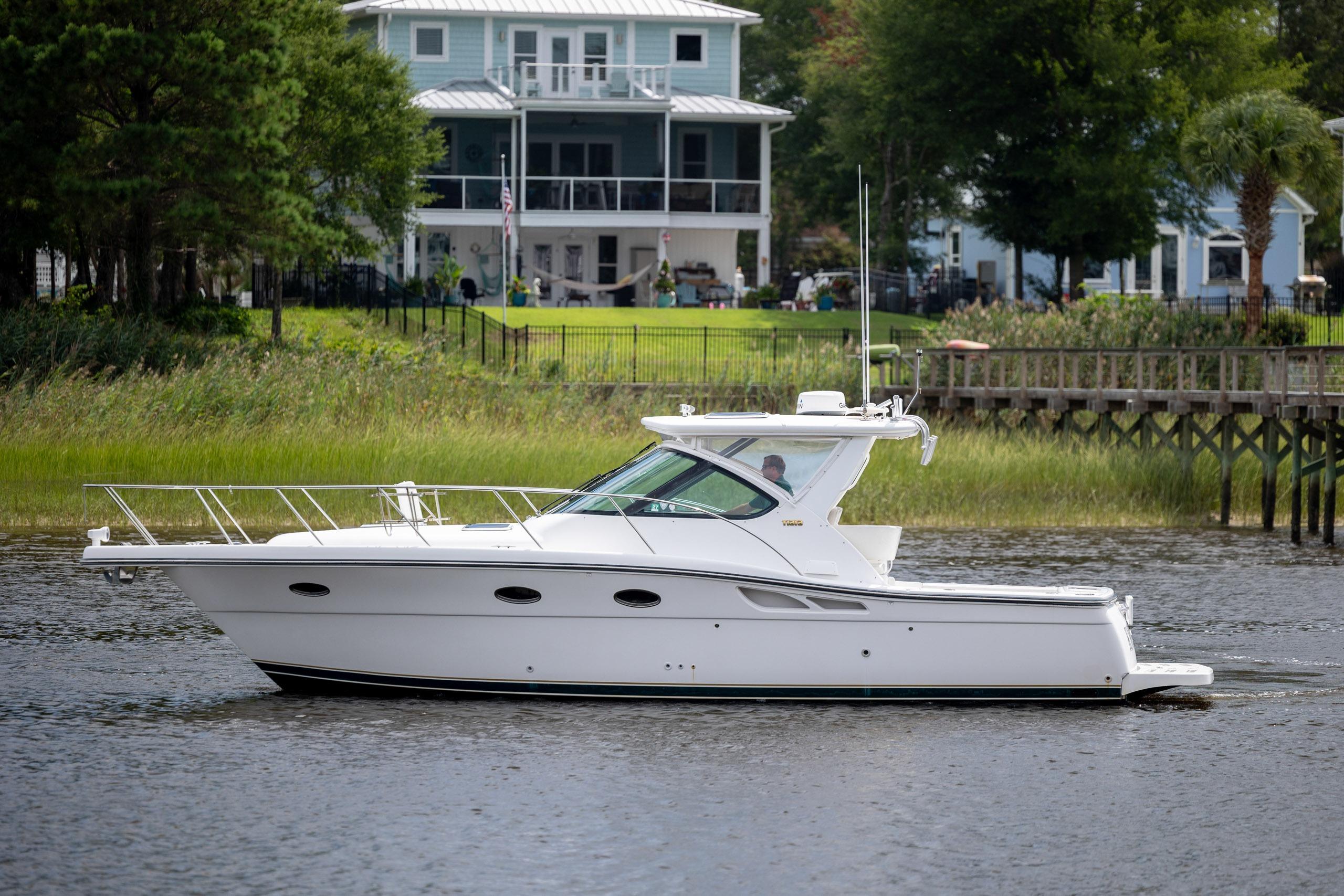 2004 Tiara Yachts 3200 Open cruising on a scenic waterfront near a house.