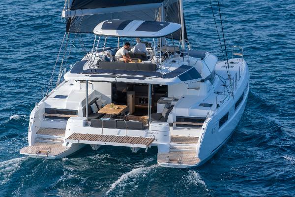 2025 Lagoon 51 ICONIC catamaran sailing on open sea, featuring spacious deck and modern design.