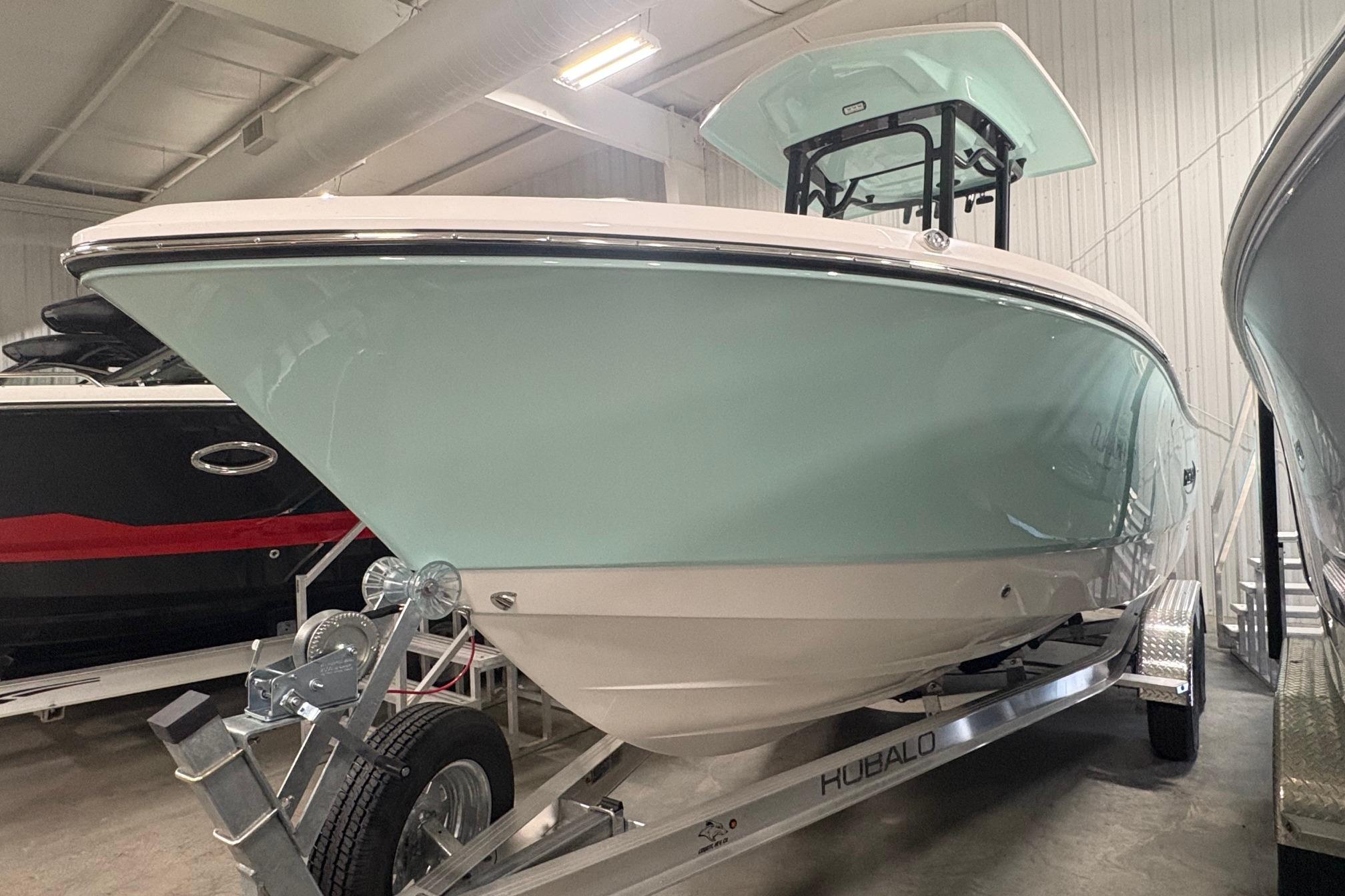 2025 Robalo R232 Explorer boat on trailer in indoor showroom.