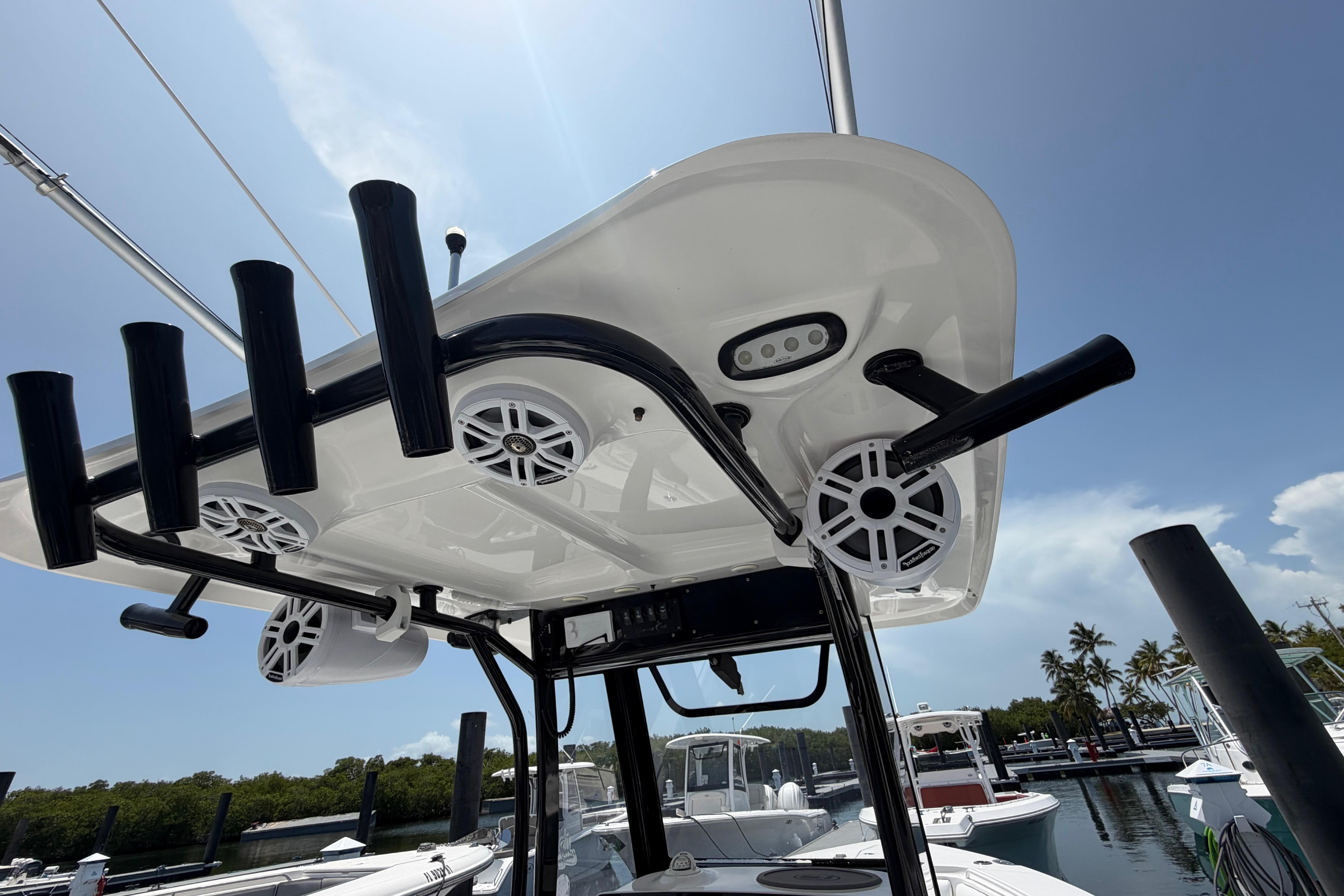 2019 Sea Hunt Gamefish 27 Coffin Box boat with rod holders and speakers at marina.