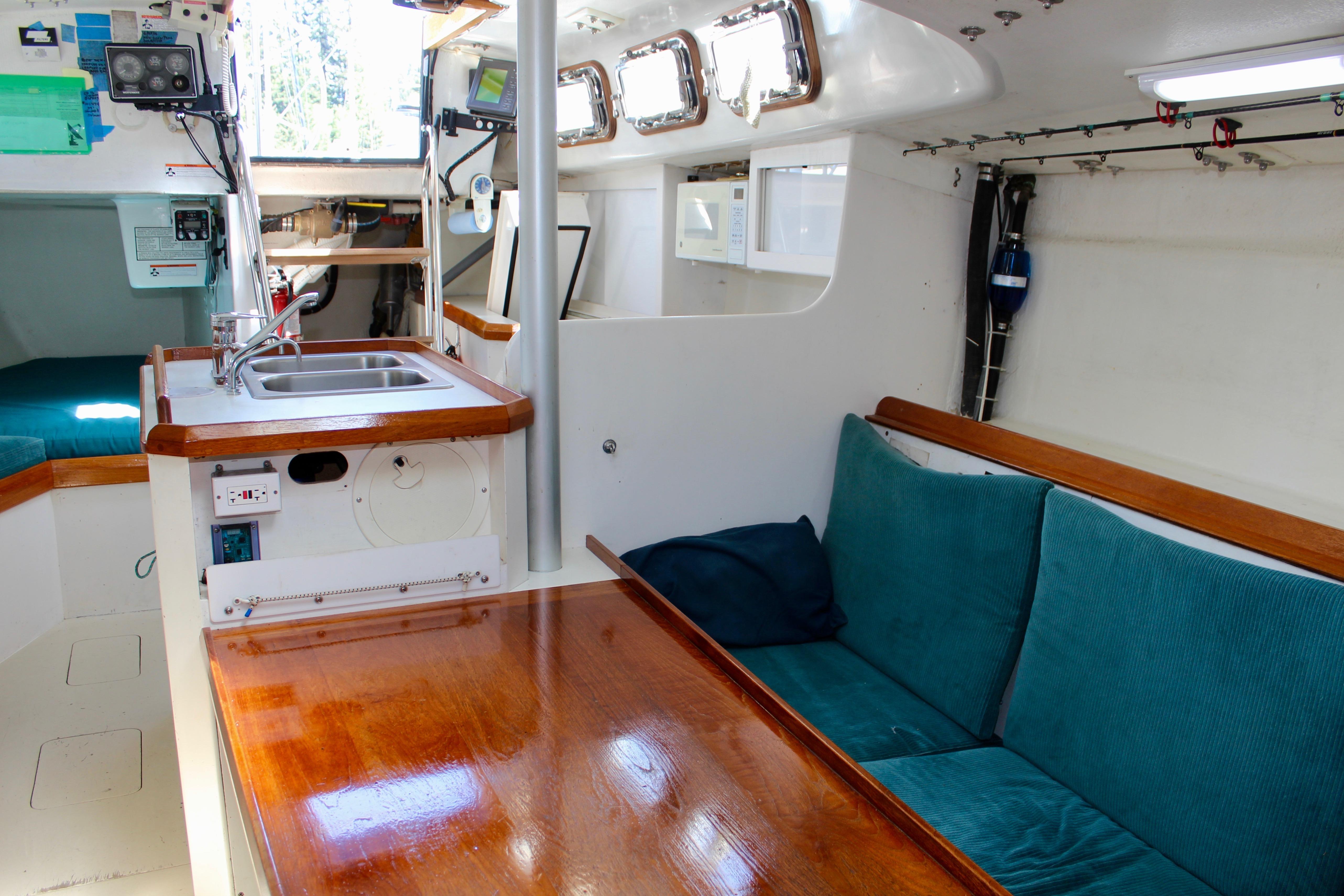 Interior of a 1993 Freya 39 sailboat with cozy seating and compact kitchen area.