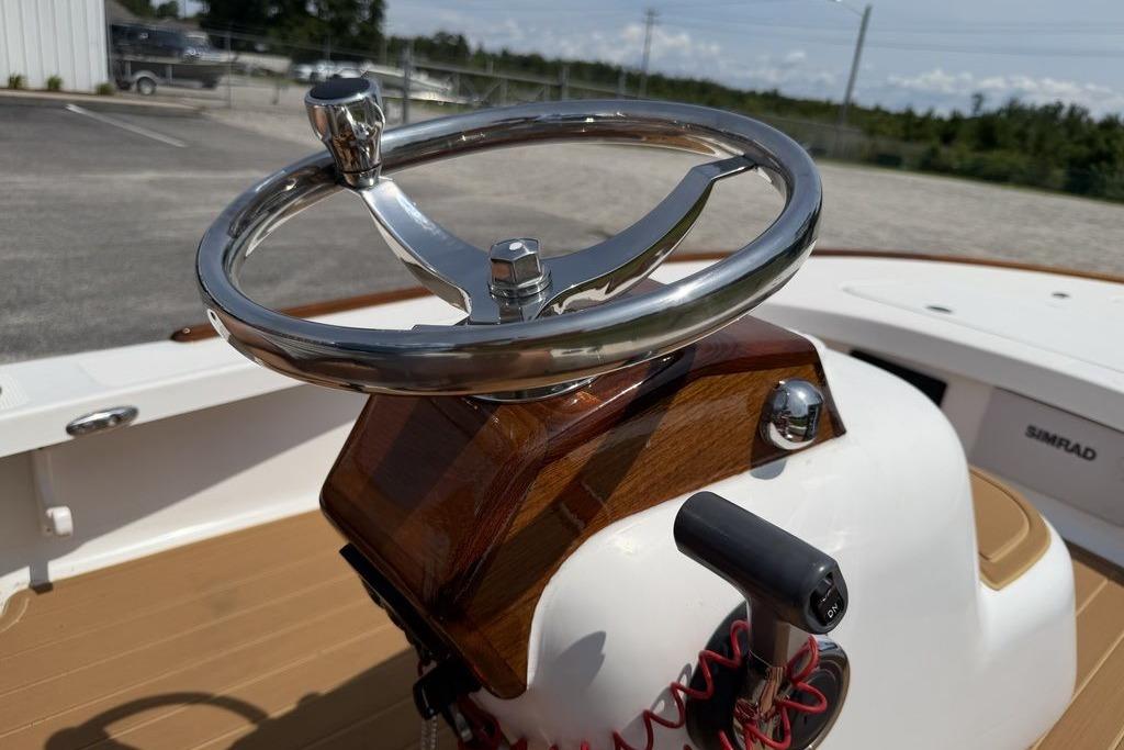 Steering wheel of a 2012 Chaos 16 Bonefish boat, featuring polished metal and wood accents.