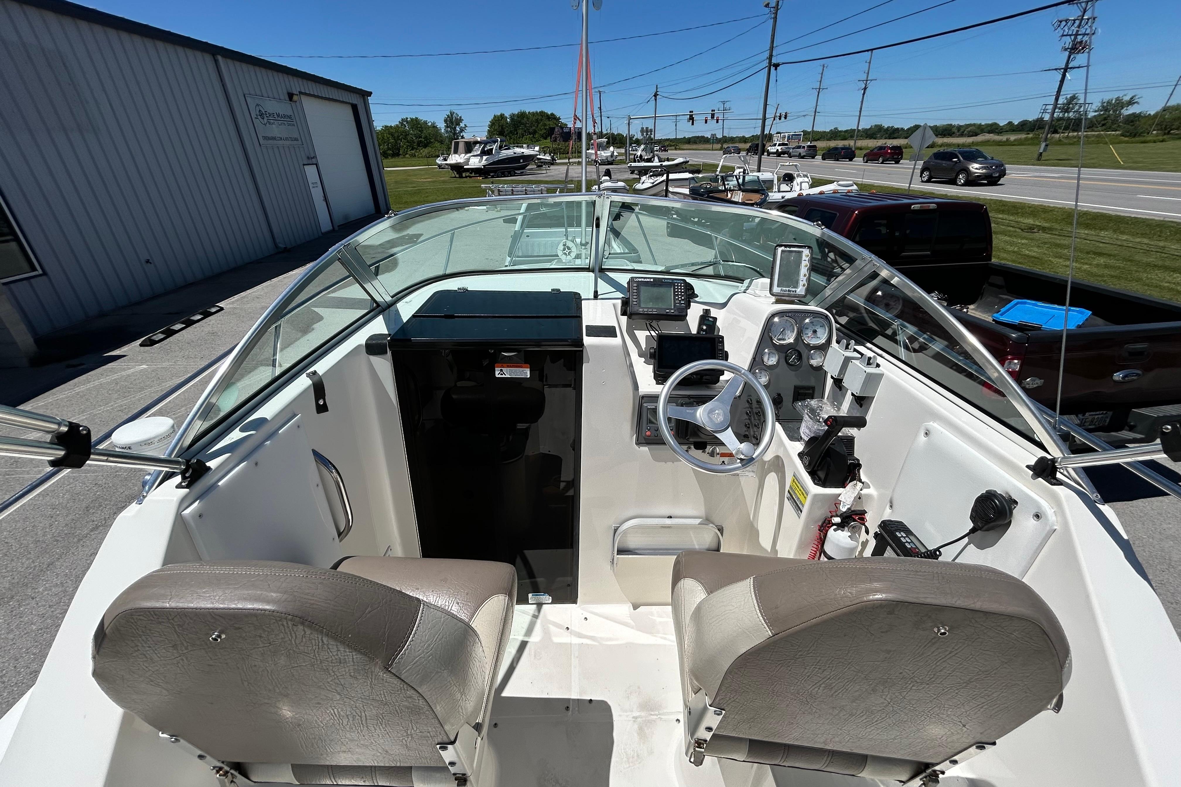 Interior view of a 2003 Wellcraft 220 Coastal boat cockpit with steering wheel and controls.