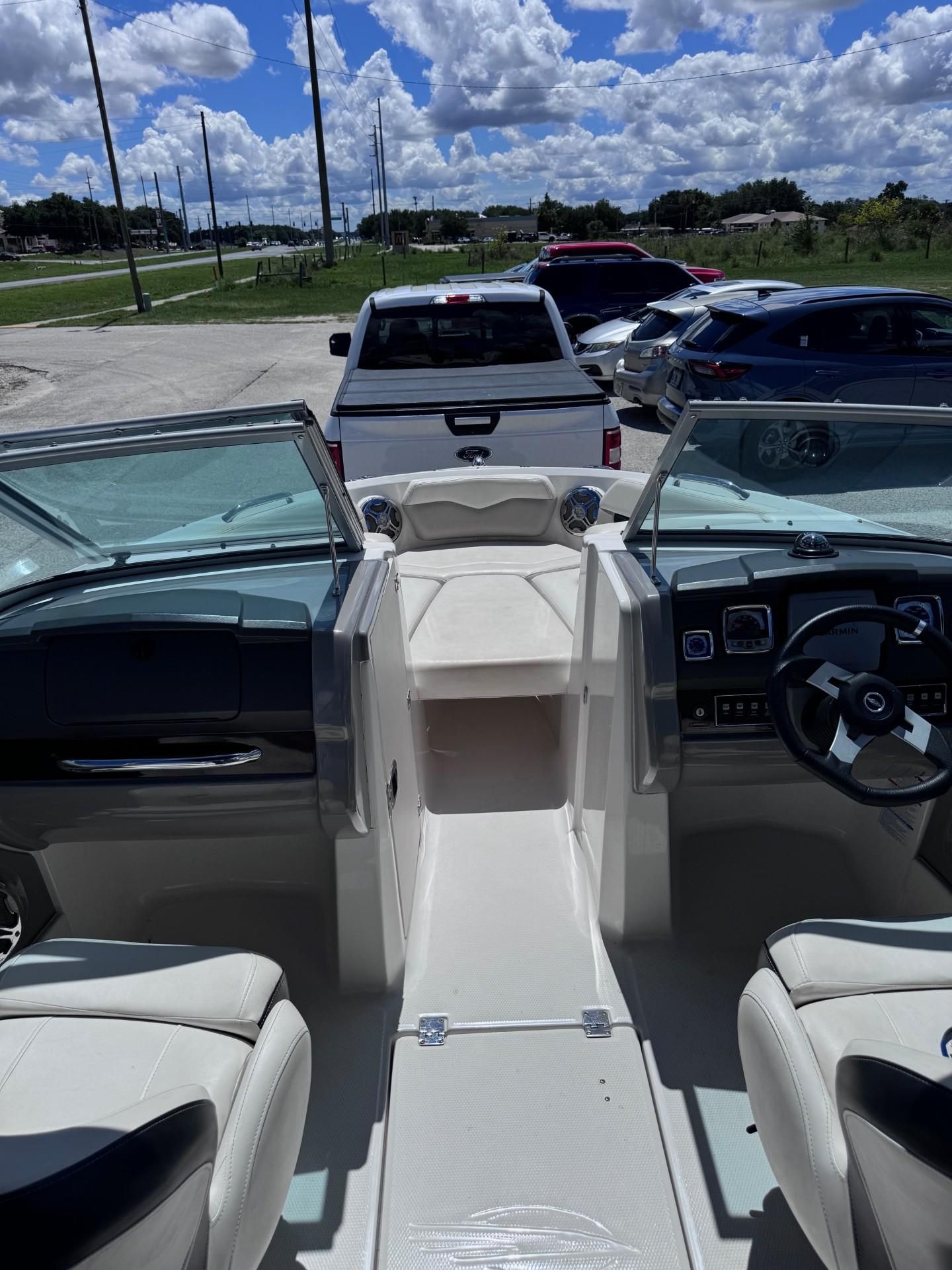 Interior view of a Chaparral 206 SSi boat with white seats and a helm station.
