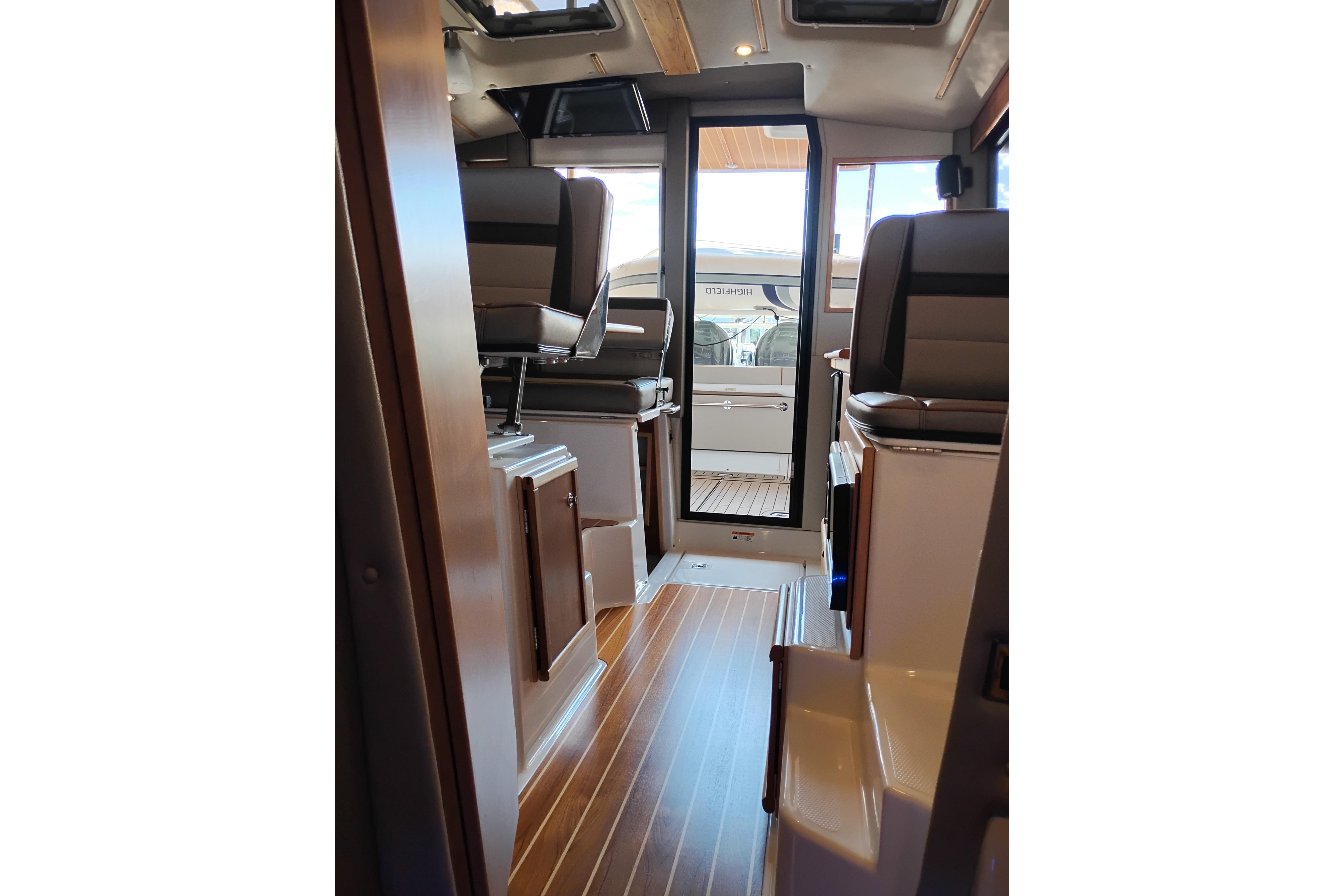 Interior view of 2022 Cutwater C-32 Coupe boat with sleek wood flooring.