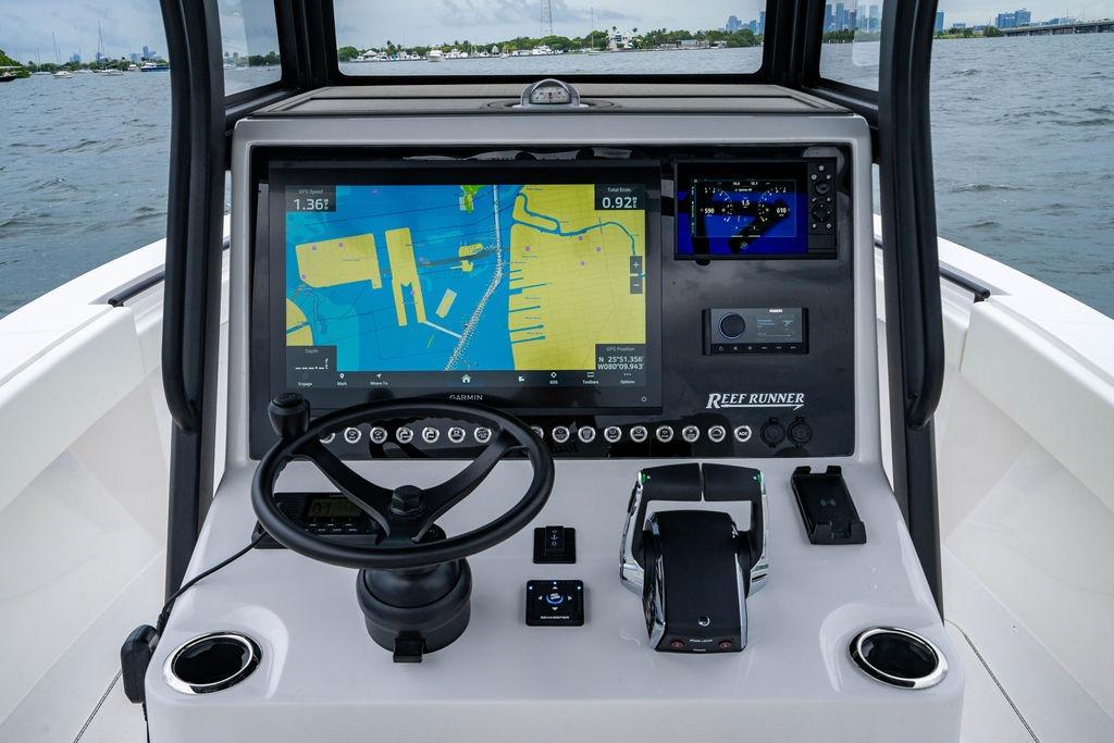 2027 Reef Runner 280 boat dashboard with navigation screens and controls on open water.