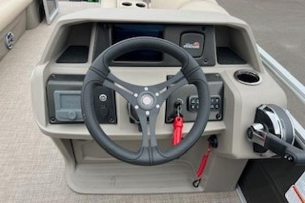 2024 Sun Tracker Party Barge 24 DLX steering console with controls and cup holder.