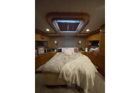Cozy bedroom interior of 1994 Johnson High-Tech 65 Euro yacht with skylight and elegant bedding.