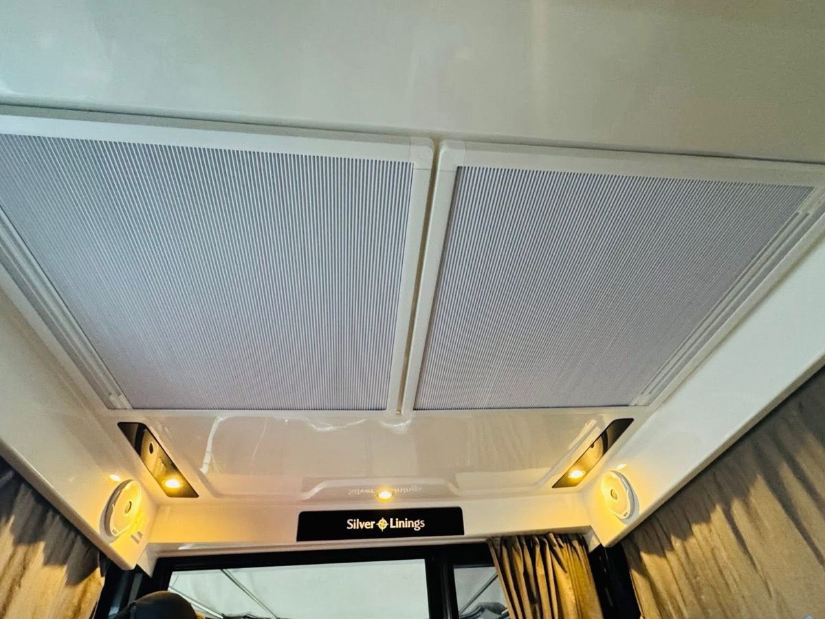 Interior view of the Jeanneau NC 895 with ceiling lights and curtains.