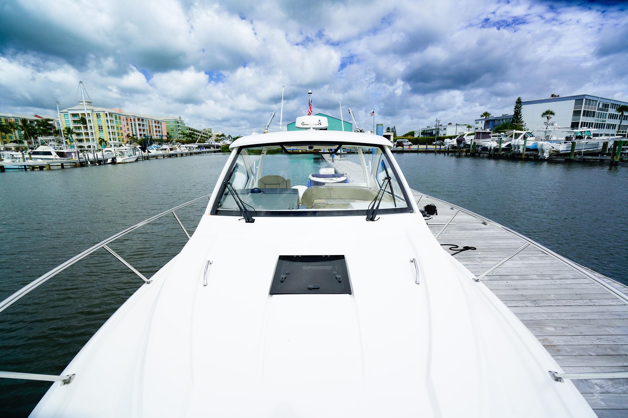 2020 Pursuit OS 325 Offshore boat docked at marina under cloudy sky.